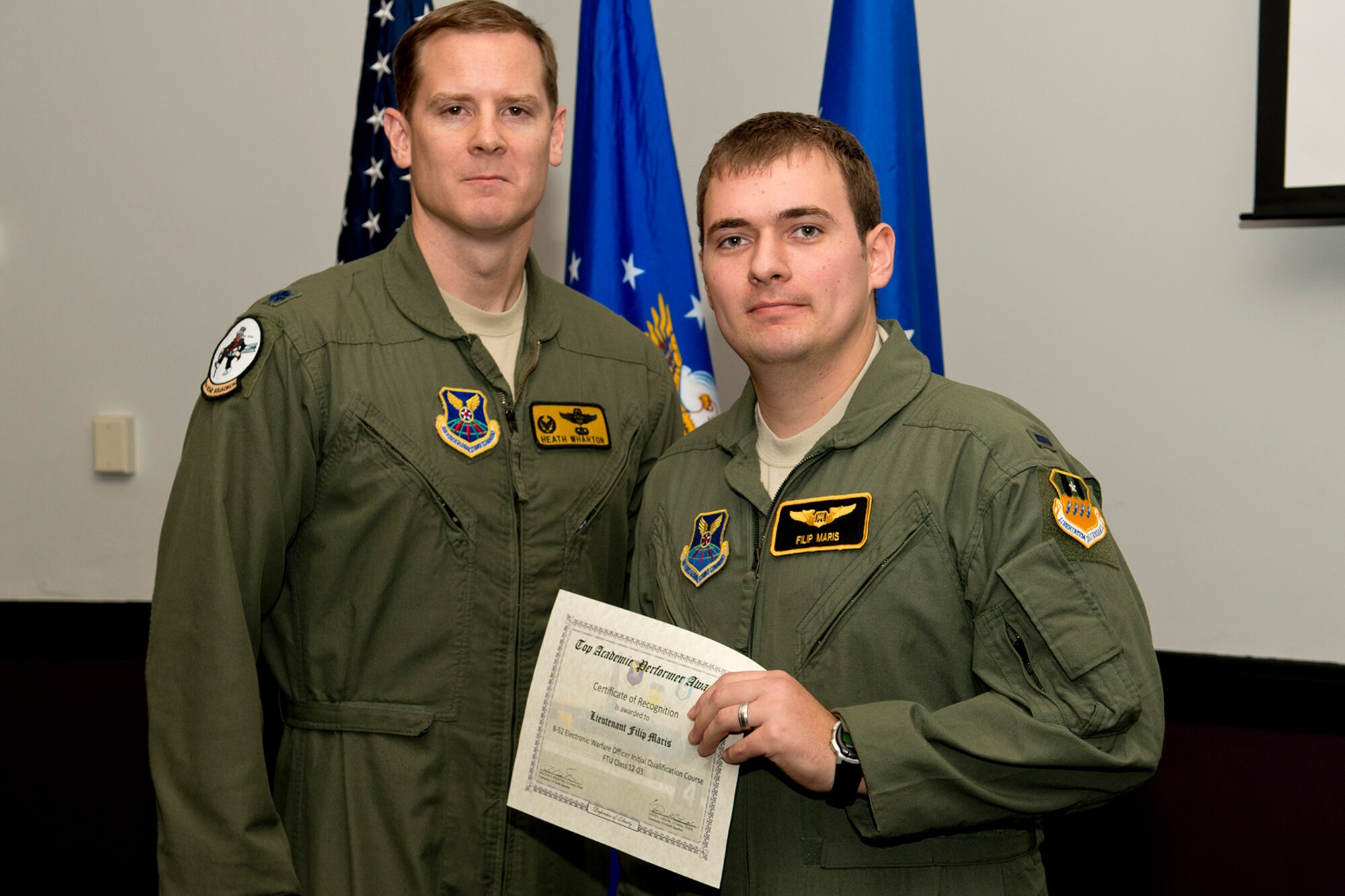 U.S. Air Force Lt. Col. William Wharton, 11th Bomb Squadron commander, presents the Electronic Warfare Officer Outstanding Academic Performer award to 1st Lt. Filip Maris during a B-52 Formal Training Unit Graduation ceremony, Dec. 21, 2012, Barksdale Air Force Base, La. Maris achieved an overall average of 96.34 percent. (U.S. Air Force photo by Master Sgt. Greg Steele/Released)