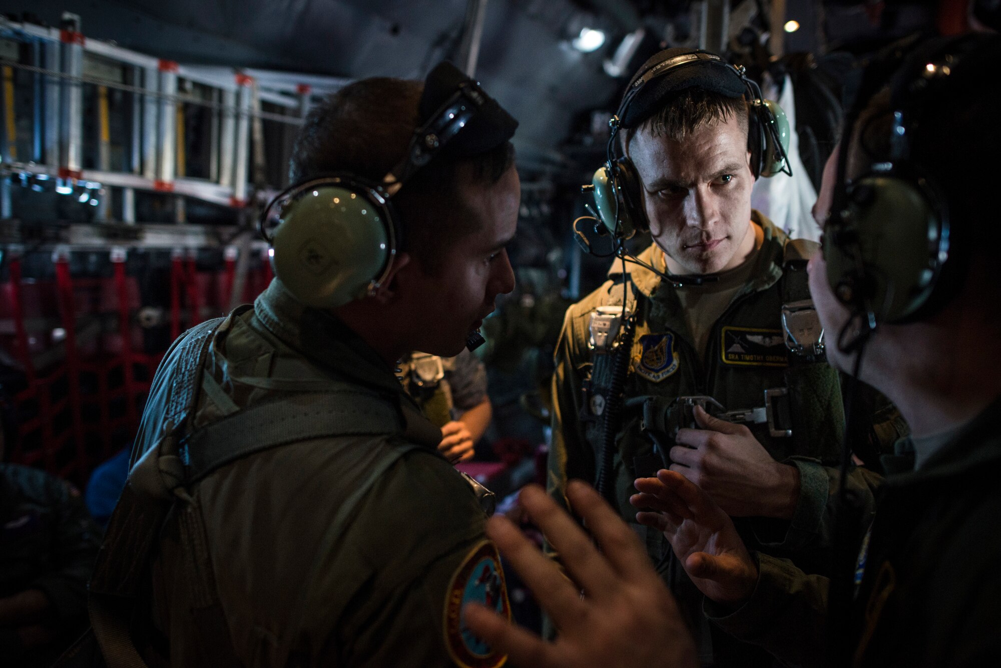 OVER MICRONESIA -- Loadmasters and a flight engineer from the 36th Airlift Squadron discuss an upcoming drop over Micronesia Dec. 12, 2012. The drop was part of Operation Christmas Drop, an event held each year for more than 60 years, dropping donated humanitarian aid and gifts to islanders in Micronesia. (U.S. Air Force photo by Tech. Sgt. Samuel Morse)