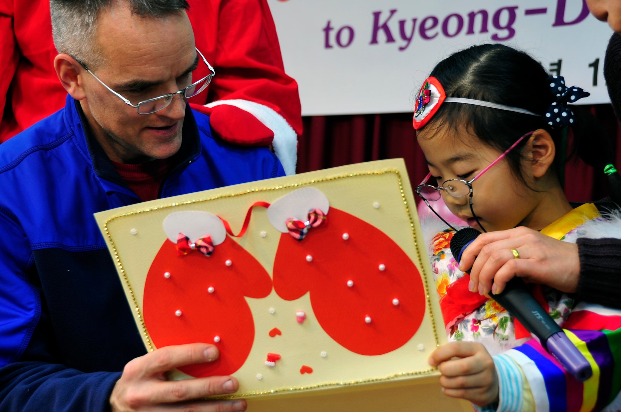 Chaplain (Capt.) Daniel Forman, 51st Fighter Wing chaplain, accepts a handmade card from a Korean girl at a local orphanage Dec. 22, 2012. Through Operation Christmas Hope, 20 orphanages and more than 2,000 children were visited. (U.S. Air Force photo/Airman 1st Class Alexis Siekert)