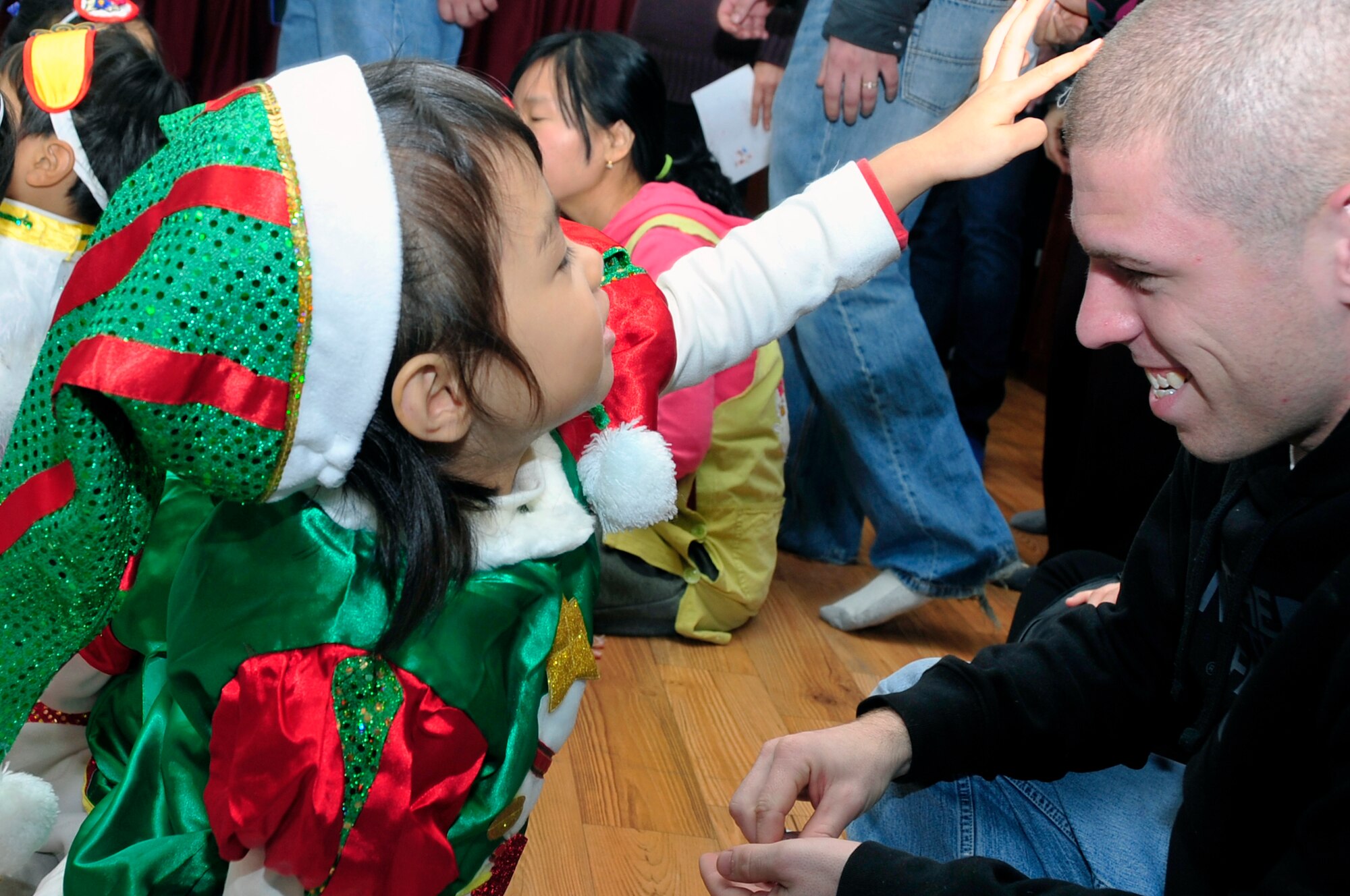 A child plays with an Osan Airman’s hair during a visit to a Korean orphanage as part of Operation Christmas Hope Dec. 22, 2012. Volunteers met with more than 2,000 orphans to spread some holiday cheer. (U.S. Air Force photo/Airman 1st Class Alexis Siekert)