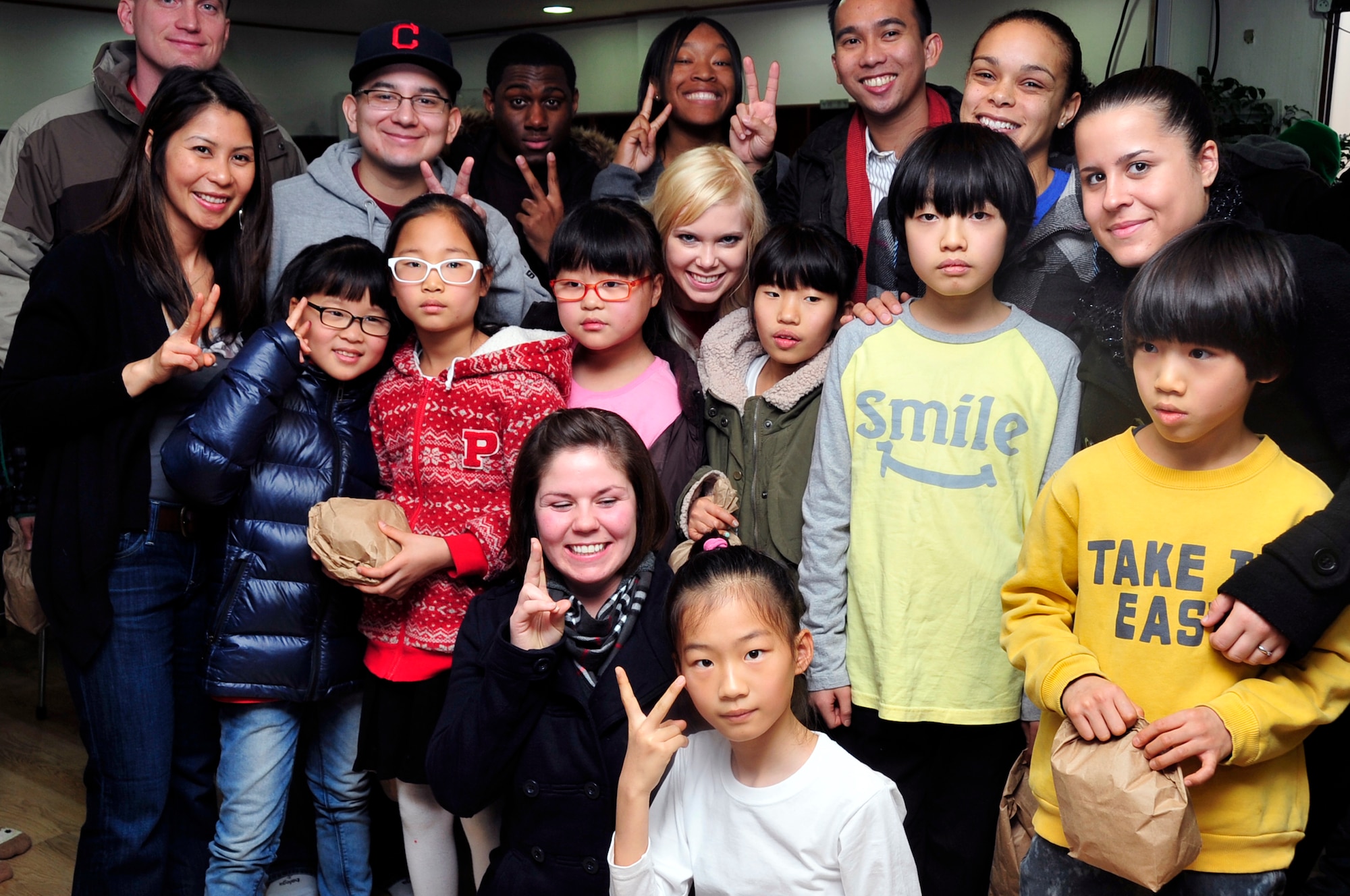 Volunteers from Team Osan pose with a group of Korean children at an orphanage Dec. 22, 2012. More than 600 volunteers visited 20 local orphanages as part of Operation Christmas Hope, an event focused on the spirit of giving. (U.S. Air Force photo/Airman 1st Class Alexis Siekert)