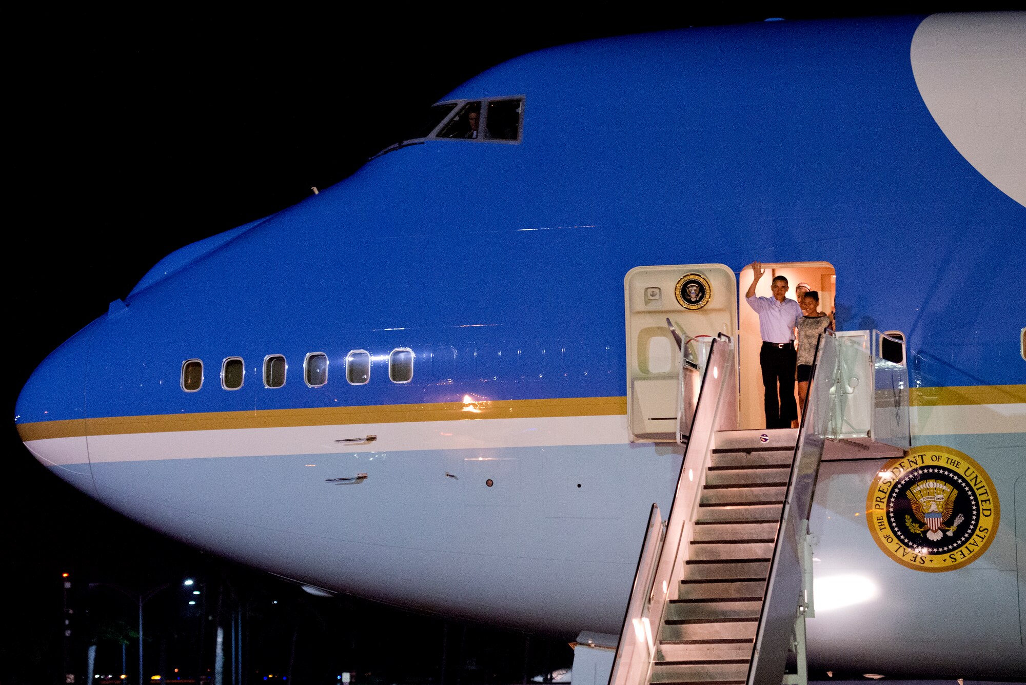 President Barack Obama waves as he steps off Air Force One with his family upon arrival at Joint Base Pearl Harbor-Hickam, Hawaii, Dec. 22. The President and his family are expected to vacation on the island of Oahu through the holiday. (U.S. Air Force photo/Staff Sgt. Mike Meares)