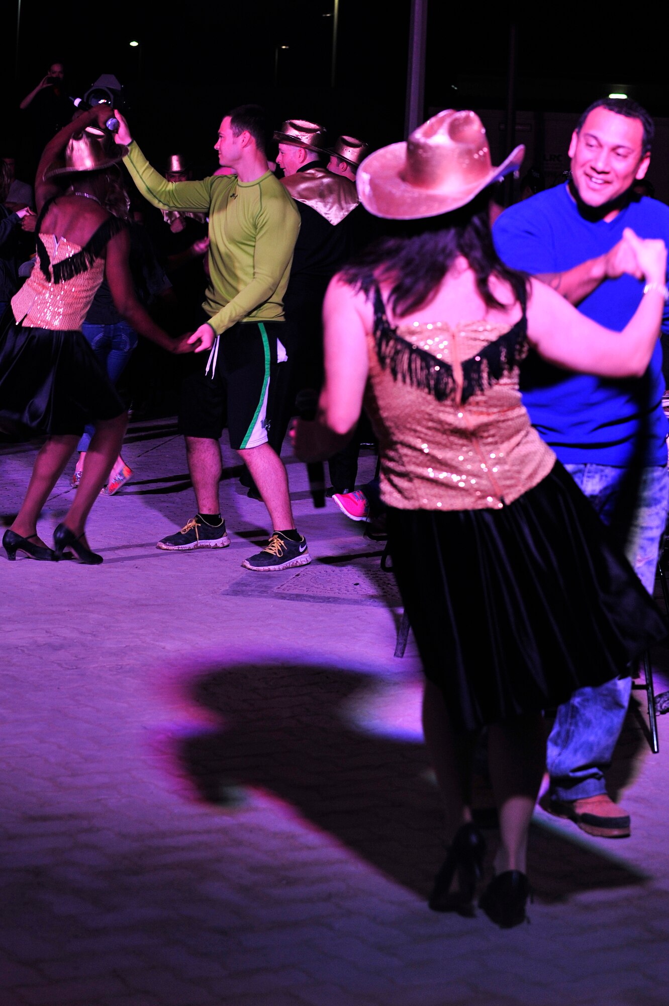 SOUTHWEST ASIA -- Tops In Blue vocalists dance with members of the 380th Expeditionary Wing during a performance on base Dec. 20, 2012. During their 10-month 2012 tour, "Listen," Tops In Blue will travel throughout the United States and more than 20 countries, to include a stop at every Air Force base in the area of responsibility. (U.S. Air Force photo/Tech. Sgt. Christina M. Styer) (RELEASED)