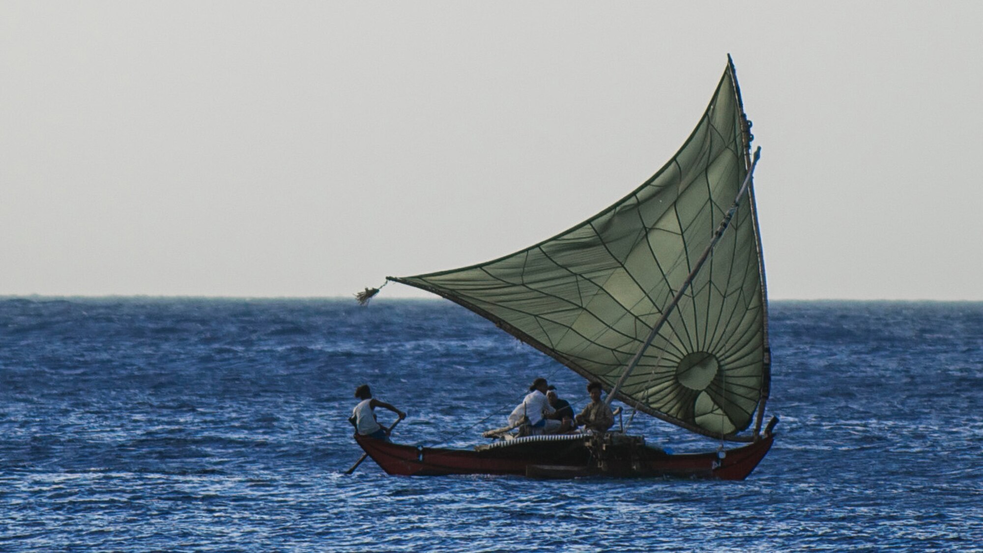 A sailboat takes to the Pacific Ocean near an island in Micronesia using an expired Army parachute as the sail on Dec. 18; 2011. The parachute was donated and used to airdrop other donated supplies to the island as part of Operation Christmas Drop. (Courtesy photo by Master Sgt. Cameron Leslie)