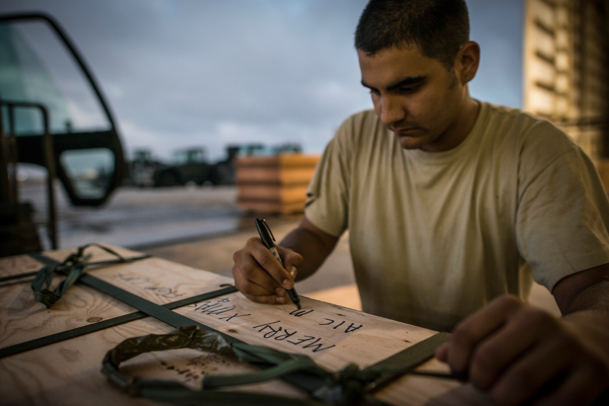 ANDERSEN AIR FORCE BASE, Guam -- Airman 1st Class Joshua McDonald, 374th Logistics Readiness combat mobility flight air transportation journeyman, writes a holiday message on a bundle at Andersen Air Force Base, Guam, Dec. 16, 2012. The bundle was later air dropped to an island in Micronesia during Operation Christmas Drop. (U.S. Air Force photo by Tech. Sgt. Samuel Morse)