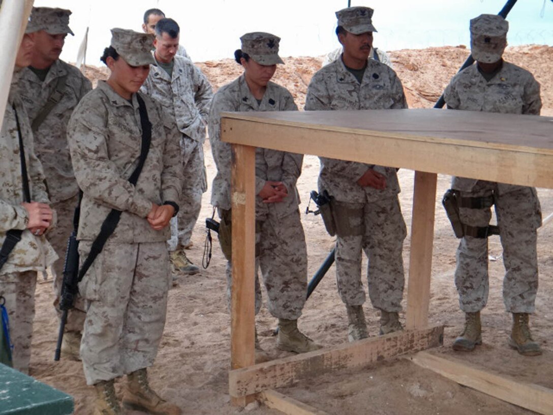 Marines and sailors assigned to Combat Logistics Battalion 15, 15th Marine Expeditionary Unit, paused during a training exercise the unit was conducting in the U.S. 5th Fleet area of responsibility, Dec. 17, to bow their heads in prayer at a memorial service for the victims and loved ones of the Newtown, Conn. shooting, Members of the battalion took a break from their daily training and operating schedule to mourn for those affected by the Sandy Hook Elementary shooting. After a moment of silence, underneath camouflaged netting, the chaplain read scripture of encouragement and said prayers for those lost during the heartbreak. The 15th MEU is deployed as part of the Peleliu Amphibious Ready Group as a U.S. Central Command theater reserve force, providing support for maritime security operations and theater security cooperation efforts in the U.S. 5th Fleet area of responsibility. (Courtesy photo)

