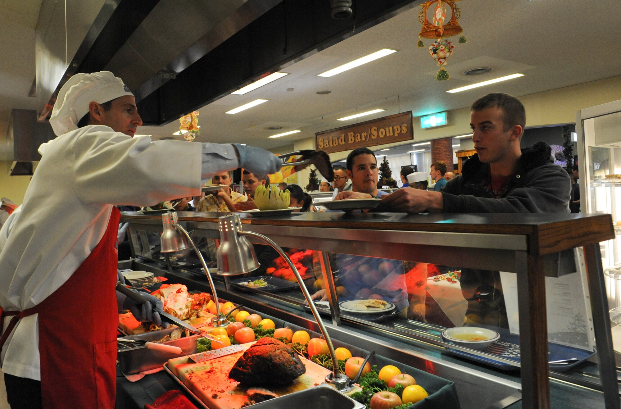 U.S. Air Force Col. Brent Markowski, 353rd Special Operations Group deputy commander, serves food to Airmen at the Marshall Dining Facility on Kadena Air Base, Japan, Dec. 25, 2012. Approximately 30 members of Kadena's leadership and their families came out to the Christmas meal, an annual tradition, to serve various dishes to Airmen, Soldiers and Marines. (U.S. Air Force photo/Airman 1st Class Malia Jenkins)