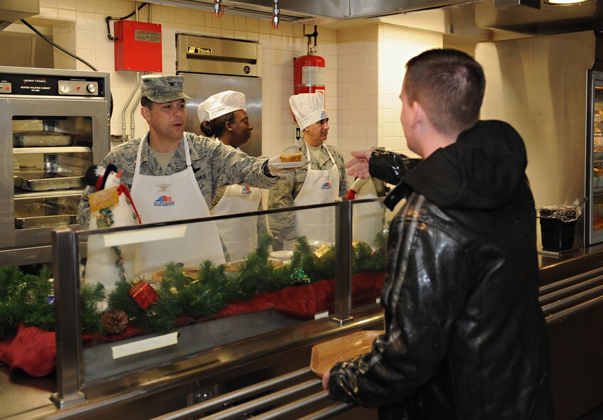 Col. Andrew Gebara, 2nd Bomb Wing commander, serves a piece of pie to a Barksdale Airman at the Red River Dining Facility on Barksdale Air Force Base, La., Dec. 25. To show their appreciation for veterans, Airmen and their families, Barksdale's leaders took time out of their day to serve them food. (U.S. Air Force photo/Airman 1st Class Benjamin Gonsier)
