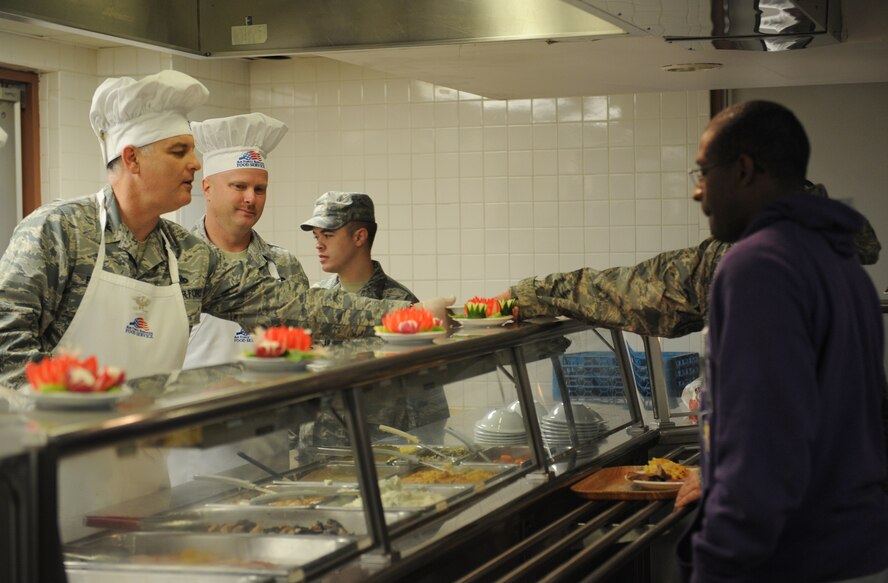 Col. Stephen Petters, 2nd Maintenance Group commander, and Chief Master Sgt. Jeffrey Buxton, 2 MXG chief, serve Team Barksdale personnel Christmas meals at the Red River Dining Facility on Barksdale Air Force Base, La., Dec. 25. To show their appreciation for veterans, Airmen and their families, Barksdale's leaders took time out of their day to serve them food. (U.S. Air Force photo/Airman 1st Class Benjamin Gonsier)
