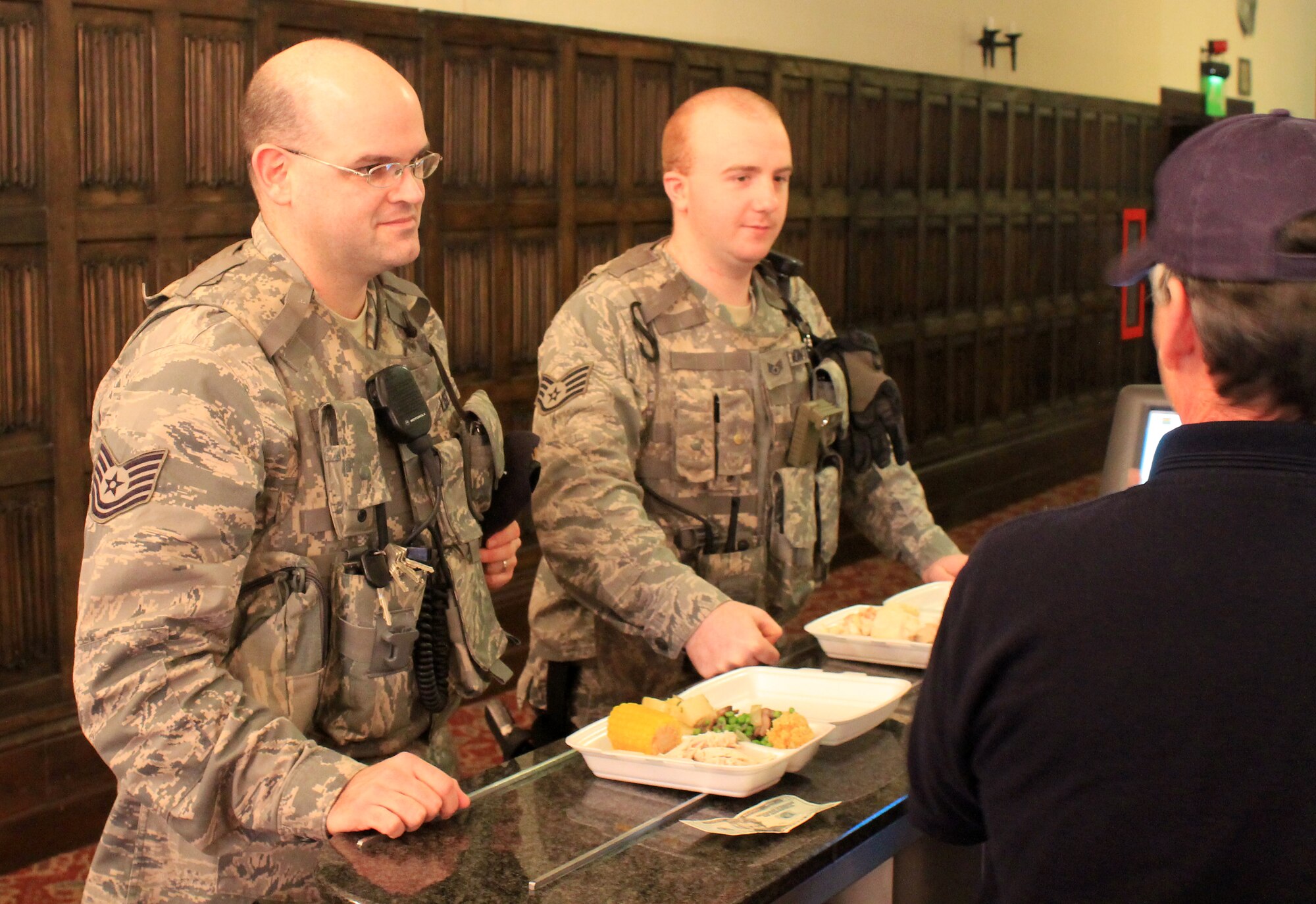 Tech. Sgt. Ross List (left) and Staff Sgt. Daniel Montgomery, both from the 100th Security Forces Squadron, purchase their Christmas lunch from Brad Workman, 100th Force Support Squadron, at the Gateway Dining Facility on Dec. 25, 2012, at RAF Mildenhall, England. List is a Nashville native, Montgomery is a Frankfurt, Ohio, native and Workman is a Panama City Beach, Fla., native. The dining facility served a special holiday meal for all authorized patrons from 11 a.m. – 4 p.m. The meal included a shrimp cocktail appetizer, ham, turkey, roast beef and stuffing among a wide variety of other traditional dishes. Throughout the day, various commanders, chief master sergeants, first sergeants and other leaders from Team Mildenhall served the meal to dining facility customers. (U.S. Air Force photo by Capt. Jason Smith/Released)