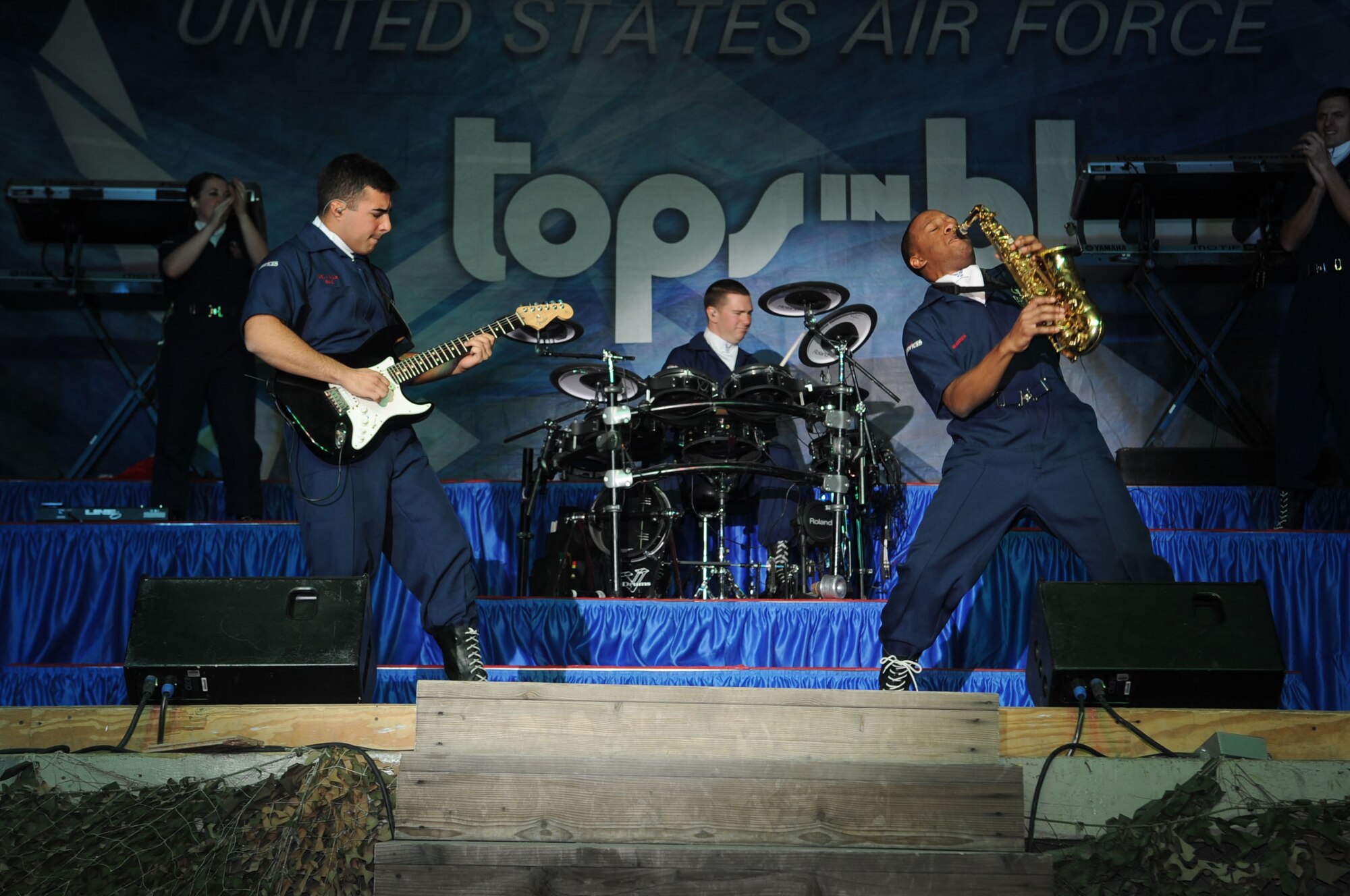 BAGRAM AIRFIELD, Afghanistan - Senior Airman Kenneth Del Valle Ruiz (on guitar) and Airman 1st Class Wynton Warren (on saxophone) have an instrument duel during a Tops in Blue performance here Dec. 24, 2012. Tops in Blue serves as an expeditionary entertainment unit that provides quality entertainment to personnel stationed worldwide at remote and deployed locations.  (U.S. Air Force photo/Staff Sgt. David Dobrydney)