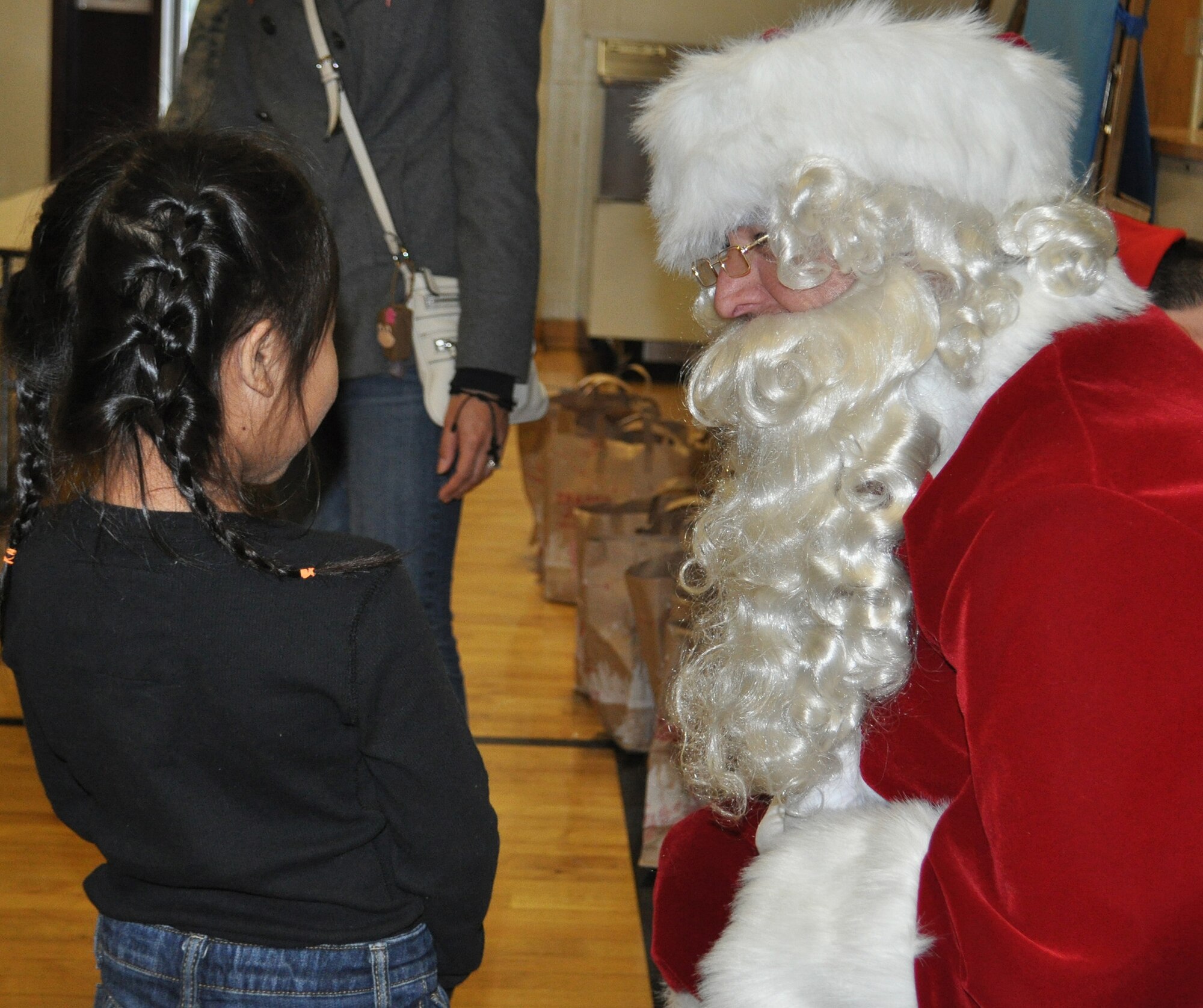 TRAVIS AIR FORCE BASE, Calif. Santa, aka Chief Master Sgt. Mark Kloeppel, listens intently to the special holiday wish of a kindergartener. Along with about a dozen of his Airmen elves, he visited Cleo Gordon Elementary, and three other schools, as part of Operation Teddy bear. Santa patiently listened to every child's gift requests, and gave each of them a bag with a book, some goodies, and, of course, a Teddy bear. Kloeppel is the senior air reserve technician for the 349th Medical Group at Travis. (U.S. Air Force photo/Senior Master Sgt. Ellen Hatfield)