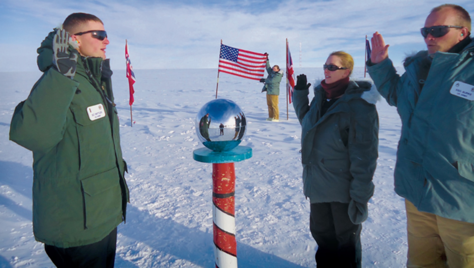 Second Lieutenant Bill Battles administers the oath of enlistment to Staff Sergeant Joe Burke and Sergeant Brandi Manuel at the Ceremonial South Pole. (U.S. Army courtesy photo/Released)