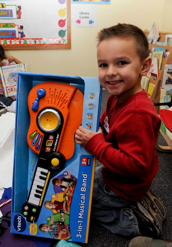 Xander Palomarez, a four and a half year old child enrolled in the Youth and Family Services Child Care program, holds up his new toy gift he received from Santa Claus during the 28th Operations Group Angel Tree program celebration at the Youth and Family Services Center in Rapid City, S.D., Dec. 18, 2012. Two hundred gifts were donated and given to the children this holiday season. (U.S. Air Force photo by Airman 1st Class Anania Tekurio/Released)