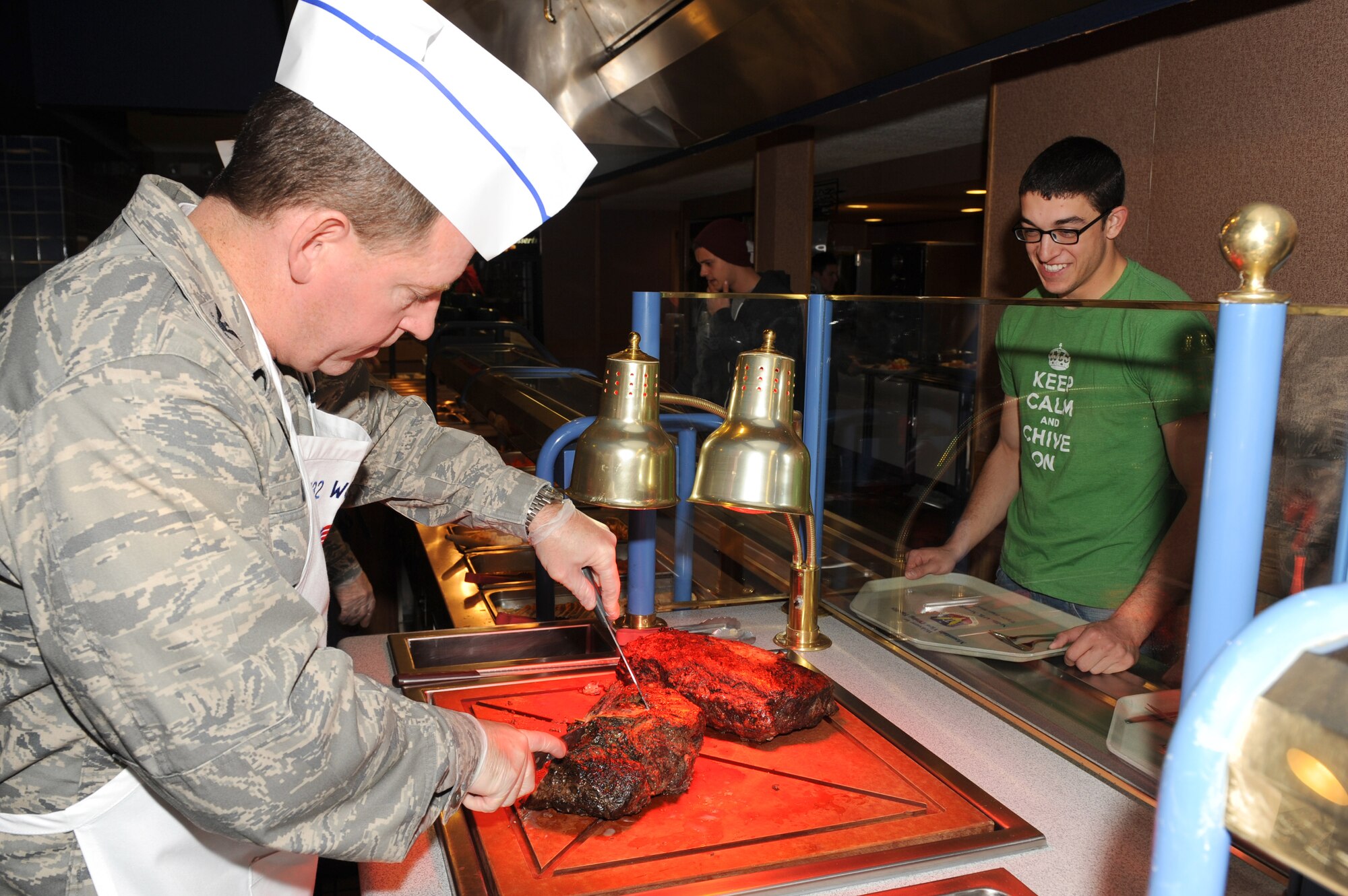 U.S. Air Force Col. Jim Hecker, 432nd Wing commander, cuts roast beef for Airman 1st Class Anthony Intorre, 757th Aircraft Maintenance Squadron crew chief, at the Mountain View dining facility Dec. 25, 2012, at Nellis Air Force Base, Nev. Hecker and other Nellis and Creech Air Force Base leadership served Christmas lunch to military members and their families. (U.S. Air Force photo by Staff Sgt. William P. Coleman)

  

