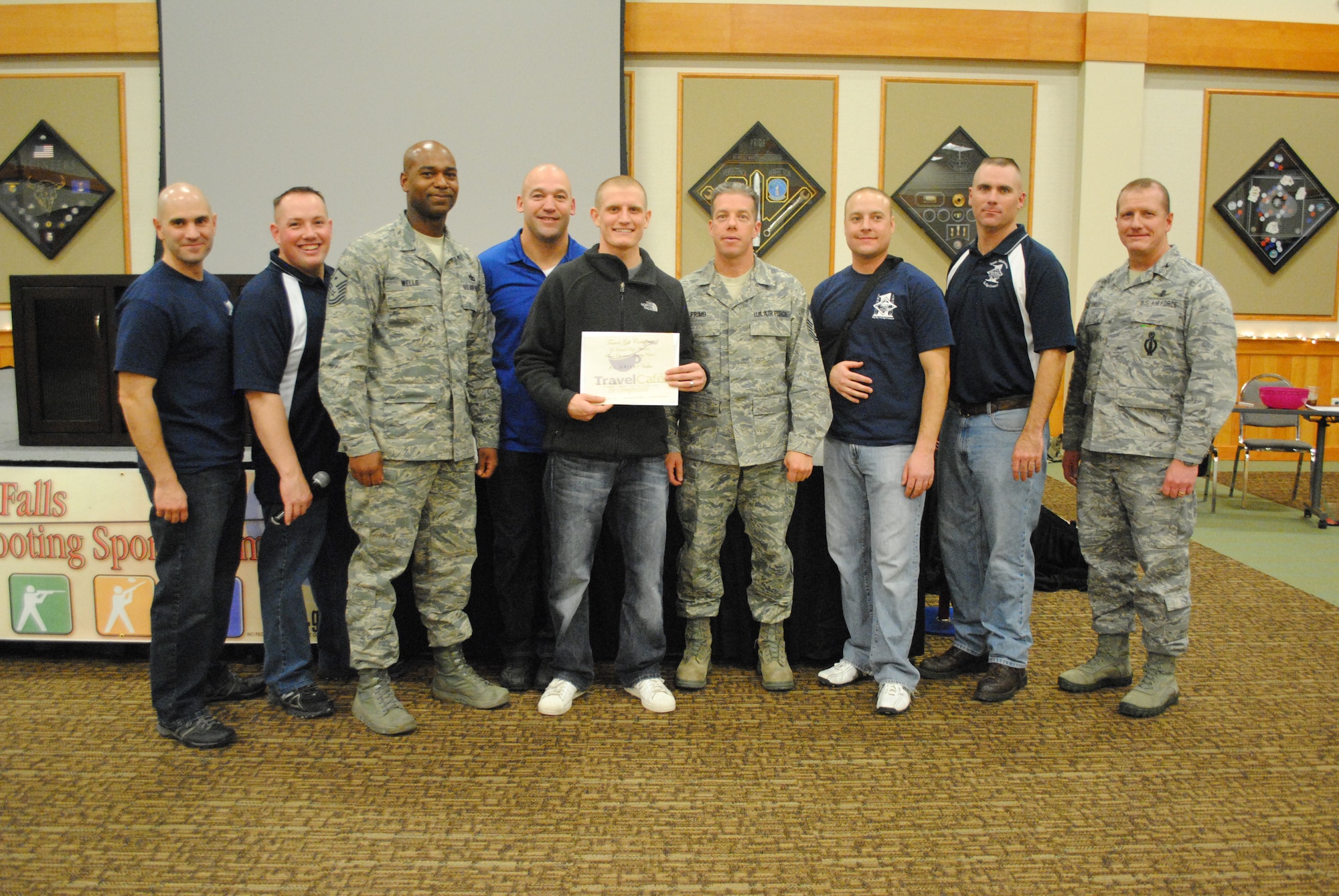 Senior Airman Alexander Stinefast, 341st Civil Engineer Squadron power production journeyman, (center) poses with a certificate for $1,500 after winning the grand prize at the Operation Holiday Cheer Wrap-Up Party at the Grizzly Bend on Dec. 12. From left to right are Master Sgt. Richard Scavola, 341st Force Support Squadron; Master Sgt. Colin Crandall, 341st Medical Group; Master Sgt. Shannon Wells, 341st Security Forces Squadron; Master Sgt. James Thoma, 341st Maintenance Operations Squadron; Stinefast; Chief Master Sgt. Michael Primo, 341st Maintenance Group; Master Sgt. William Baccus, 341st CES; Master Sgt. Shane Matt, 341st Missile Security Forces Squadron; and Col. Robert Stanley, 341st Missile Wing vice commander. (U.S. Air Force photo/Airman 1st Class Katrina Heikkinen)
