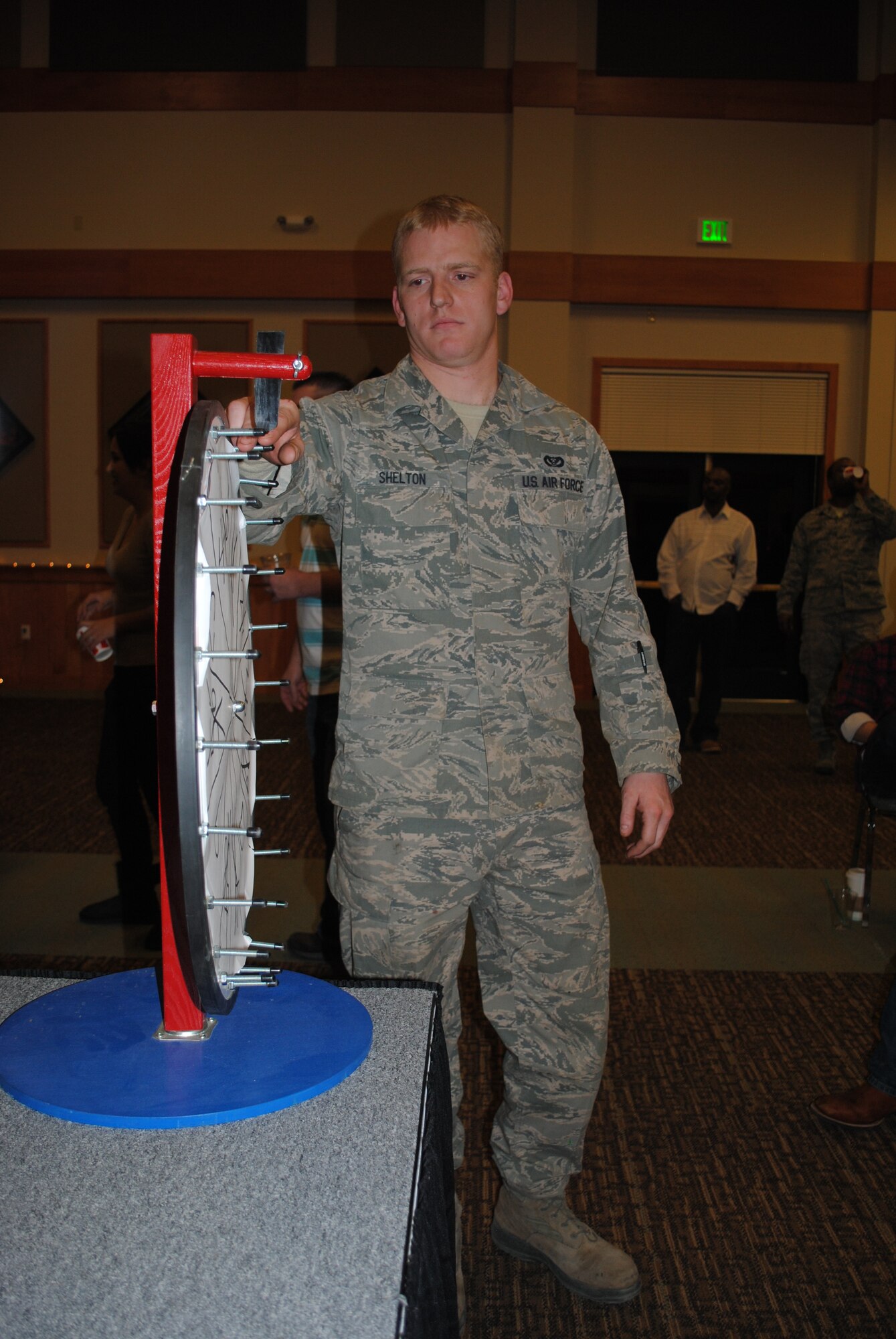 Senior Airman Douglas Shelton, 819th RED HORSE Squadron heavy equipment operator, spins a prize wheel to determine his winning prize after his raffle ticket was called. Shelton eventually became the winner of a Coach purse. (U.S. Air Force photo/Airman 1st Class Katrina Heikkinen)