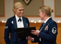 Master Sgt. Sarah Edwards, 341st Force Support Squadron Airman Leadership School commandant, hands a certificate of appreciation to Senior Airman Bryenna Brooks, 2nd Medical Operations Squadron; Barksdale Air Force Base, La.; following her speech to the ALS graduates on Dec. 18.  Brooks was named the Air Force Global Strike Command Outstanding Airman of the Year.  (U.S. Air Force photo/Beau Wade)
