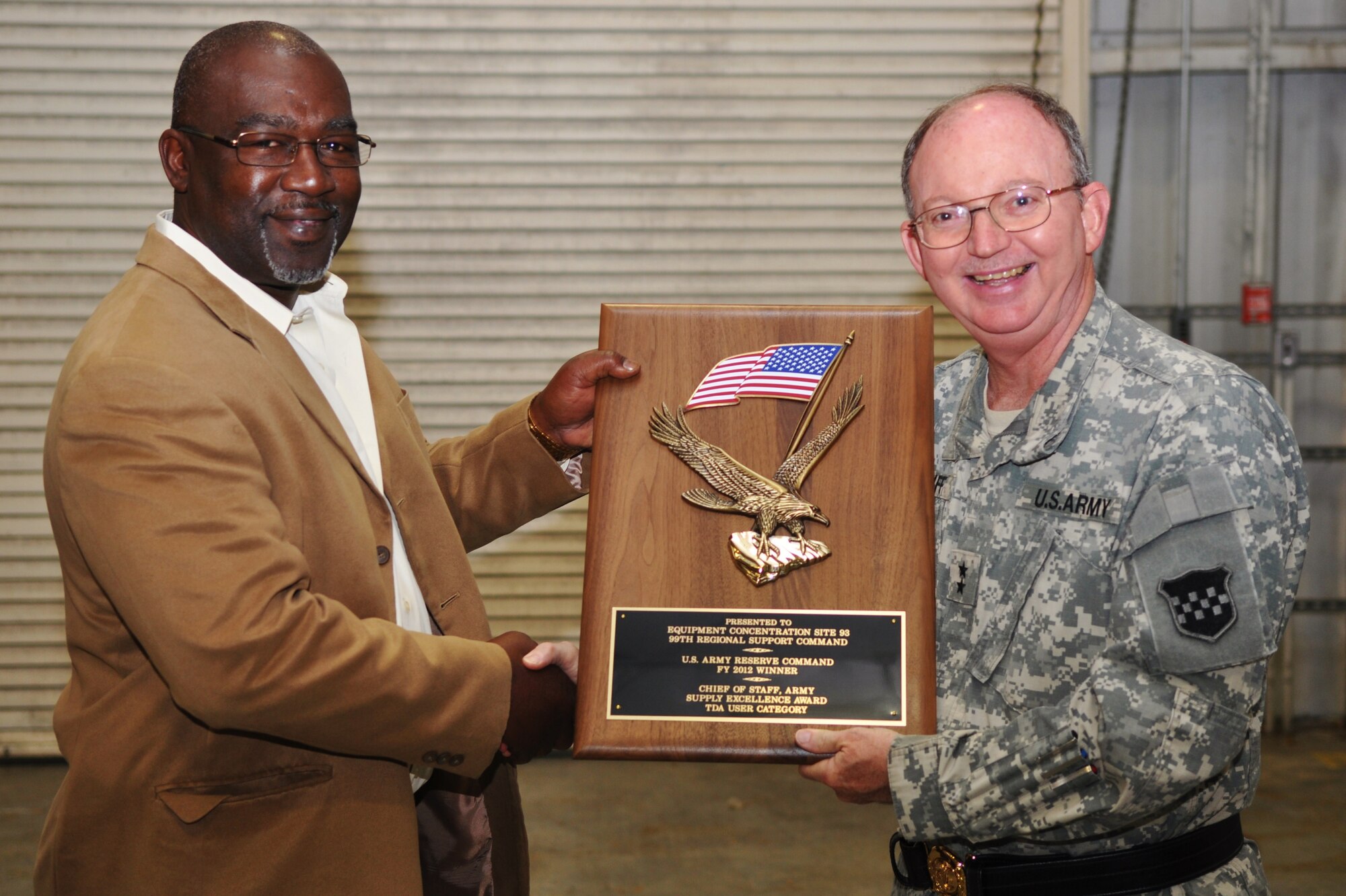 (From left) Oliver Couther, the Equipment Concentration Site 93 manager, receives the U.S. Army Reserve Command 2012 Chief of Staff of the Army Supply Excellence Award-Tables of Distribution and Allowances Category from U.S. Army Maj. Gen. William D. Razz Waff, commanding general of the 99th Regional Support Command, at Fort Eustis, Va., Dec. 19, 2012. The ESC 93, detached at Fort Eustis from its main unit at Joint Base McGuire-Dix-Lakehurst, N.J., will move on to the Department of the Army-level competition against active-duty and National Guard units. (U.S. Air Force photo by Senior Airman Jason J. Brown/Released)
