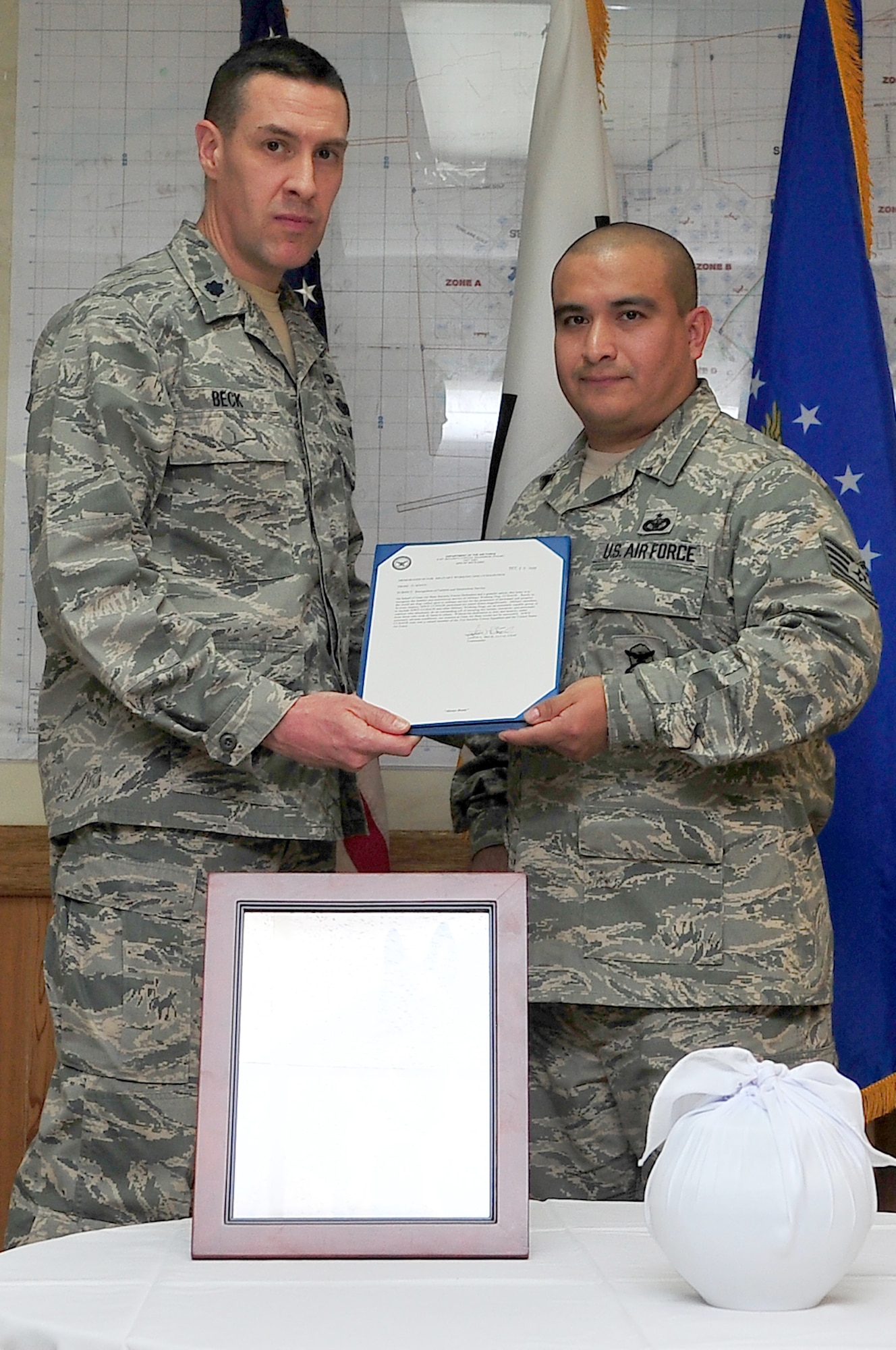 Lt. Col. Jason Beck, 51st Security Forces Squadron commander, presents Tech. Sgt. Eric Morales, 51st SFS military working dog handler, with letter of appreciation to recognize Military Working Dog CChaos’ contributions to the mission in a memorial Dec. 20, 2012. CChaos was a 12-year-old Belgian Malinois who had 11 years of active military service, with 10 of those years being assigned to Osan Air Base. (U.S. Air Force photo/Tech. Sgt. Raymond Mills) 