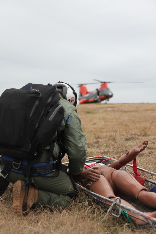 Petty Officer 3rd Class John H. Nelson, a search and rescue medical technician with Marine Transport Squadron 1, evaluates the condition of a dummy during an injured pilot training scenario as one of the squadron’s HH-46E Sea Knight helicopters awaits orders during a search and rescue exercise near Morehead City, N.C., Dec. 6. 