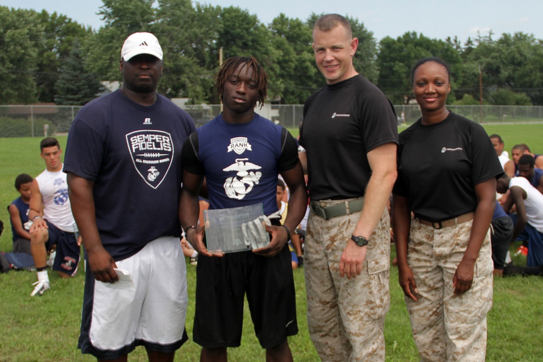 Recruiting Station Twin Cities Executive Officer Capt. Timothy O'Neil and Recruiting Substation Coon Rapids' Staff Sgt. Tyanna Tolson present D'Tavius Williams with an Excellence in Leadership Award at the Minneapolis Diamond Flight Camp July 22. Junior Rank coaches selected Williams to receive the award because he displayed great character and leadership throughout the camp. Williams, 15, will be a sophomore at Southwest High School.