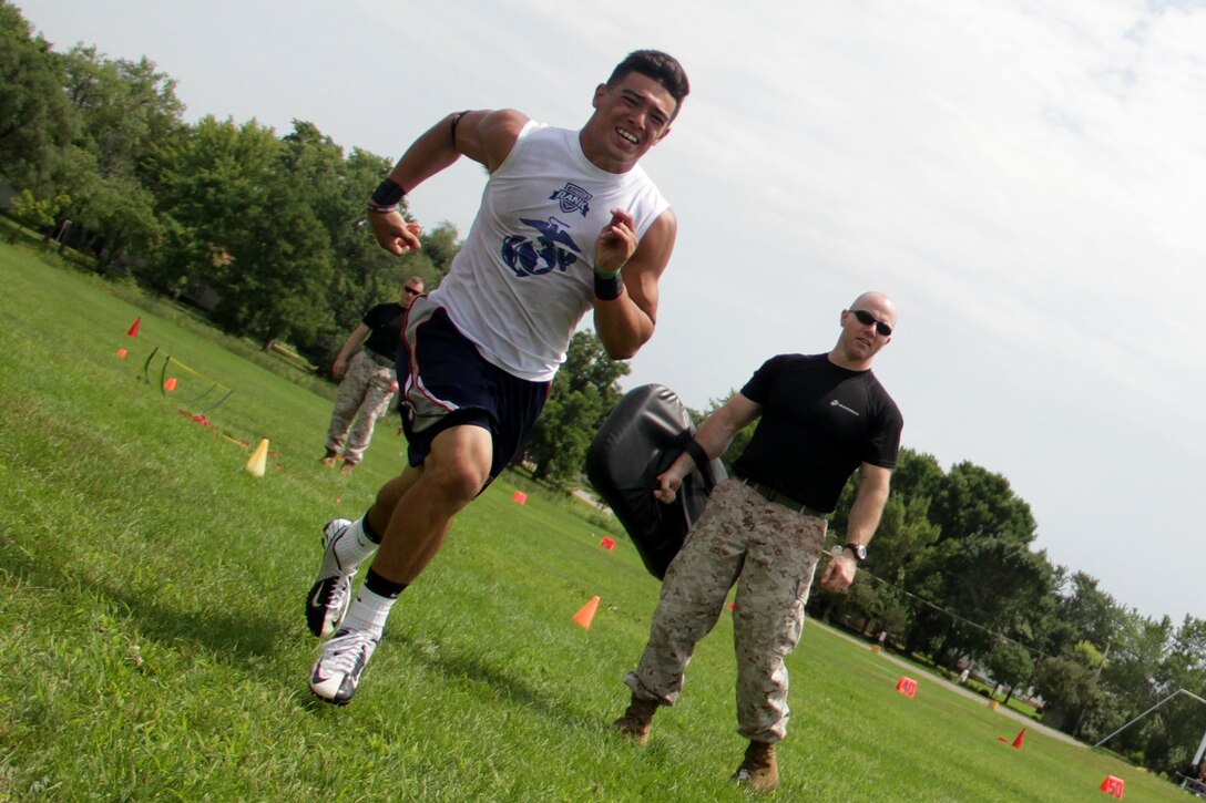 Anastacio VandenBosch-Romo runs past Gunnery Sgt. Nate McIntosh during an obstacle course race at the Minneapolis Diamond Flight Camp July 22. Junior Rank coaches selected Romo to receive an Excellence in Leadership Award because he displayed great character and leadership throughout the camp. Romo, 16, will be a junior at Henry Sibley High School.