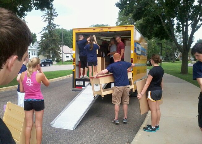 More than a dozen poolees with Recruiting Substation Woodbury help move furniture from the St. John Vianney Catholic Church to the Community of Saints School on July 25. An aspiring Marine discovered the school needed assistance, so he asked his recruiter if RSS Woodbury could help out before their Warrior Wednesday workout.