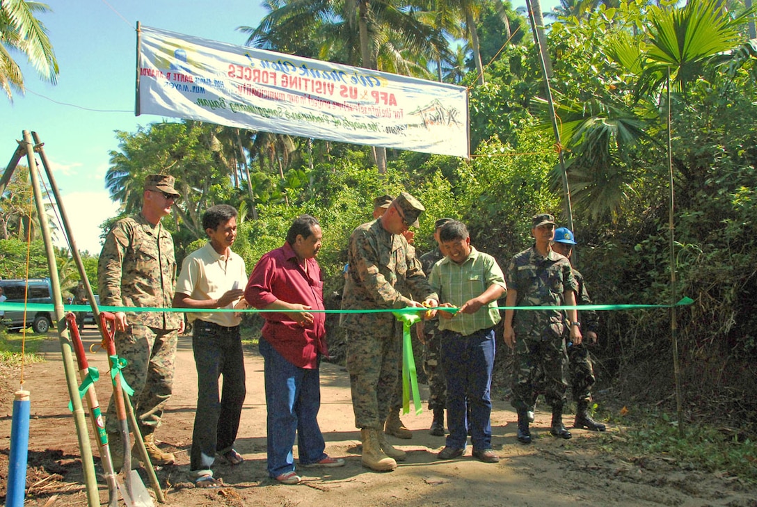 Pio Duran Municipal Mayor Dante Arandia cuts the ceremonial ribbon with U.S. Marine Corps Colonel Frank Ricapito, the deputy commander for the Joint Civil Military Operations Task Force during a groundbreaking ceremony for a Balikatan 2009 engineering civic action project to build a new road in Pio Duran, Albay Province, Philippines April 2, 2009.  Combined Philippine and U.S. teams provide medical, dental, veterinary, and engineering services. These events allow U.S. and Philippine militaries to learn from one another as well as help the local communities in humanitarian relief efforts. (U.S. Marine Corps photo by Corporal Heather Golden/Released)