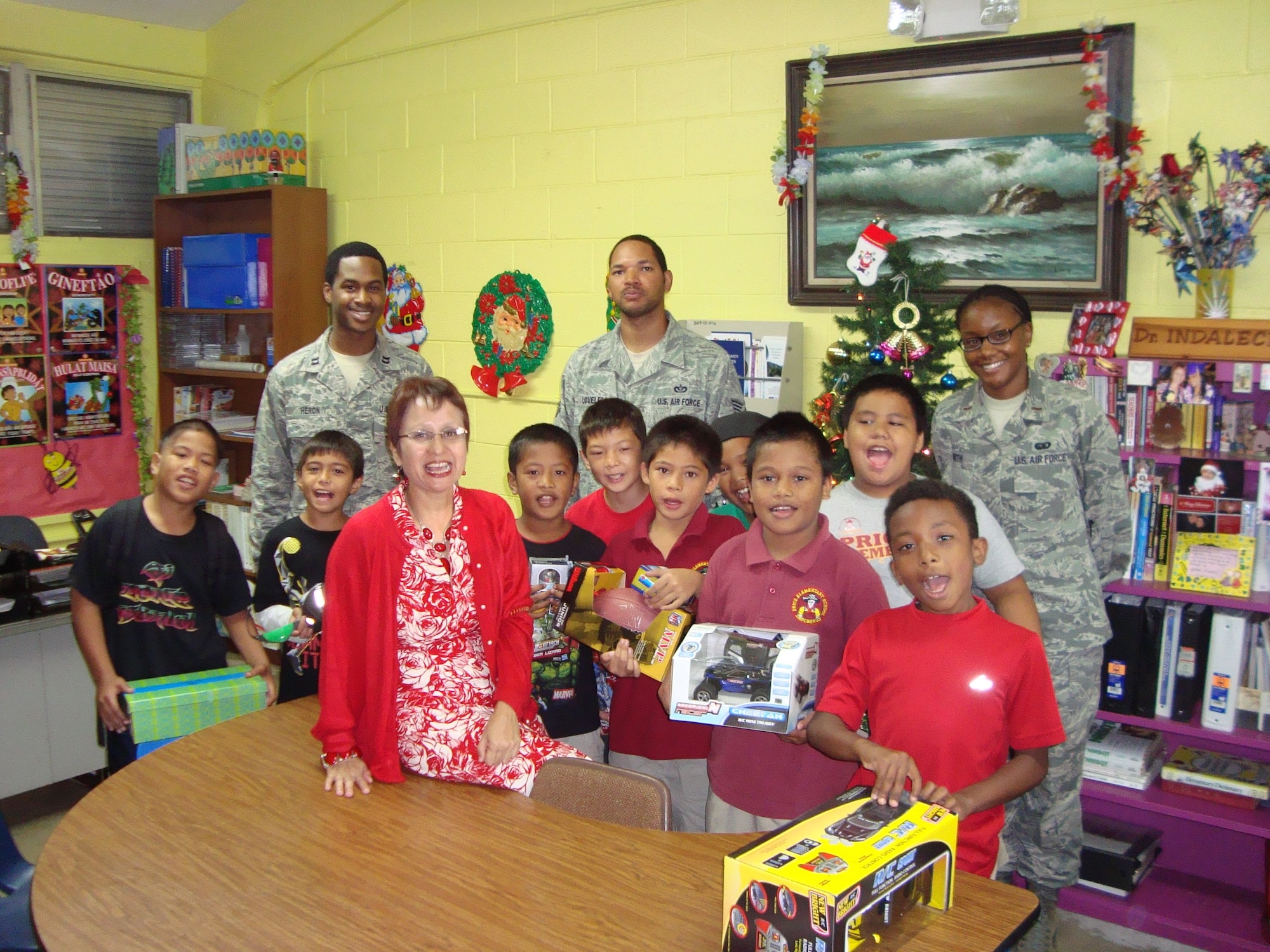 TAMUNING, Guam—Members from the Andersen African American Heritage Association give presents to local children at Tamuning Elementary School December 21, 2012. A collaboration between members of the AAHA and the Andersen Chapel gathered gifts for local children before the holiday season. A month of planning led to the formation of an Angel Tree donation system for children in the Big Brother, Big Sister Organization. (Contributed Photo)