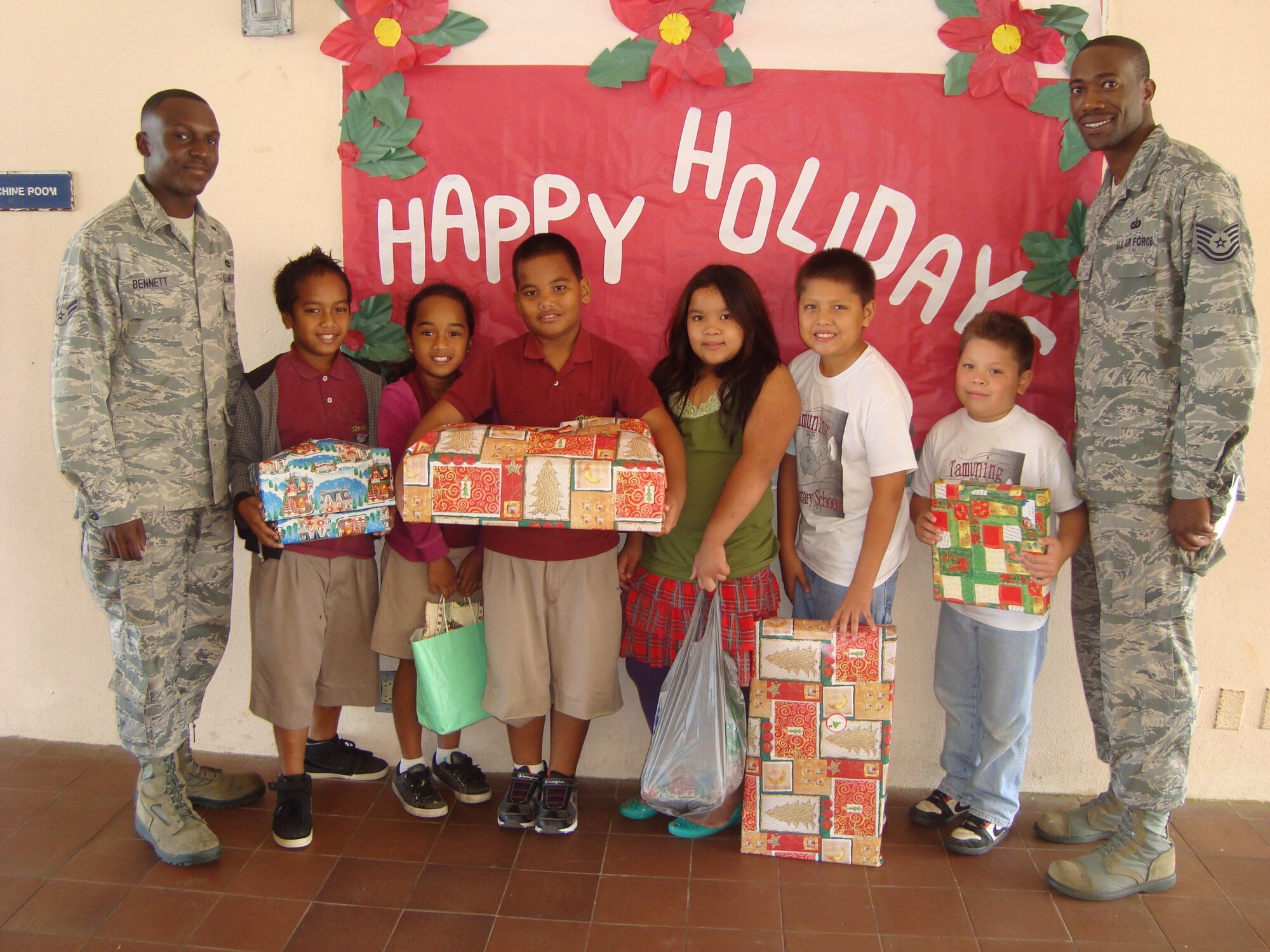 MANGILAO, Guam—Members from the Andersen African American Heritage Association give presents to local children at Price Elementary School December 21, 2012. A collaboration between members of the AAHA and the Andersen Chapel gathered gifts for local children before the holiday season. A month of planning led to the formation of an Angel Tree donation system for children in the Big Brother, Big Sister Organization. (Contributed Photo)