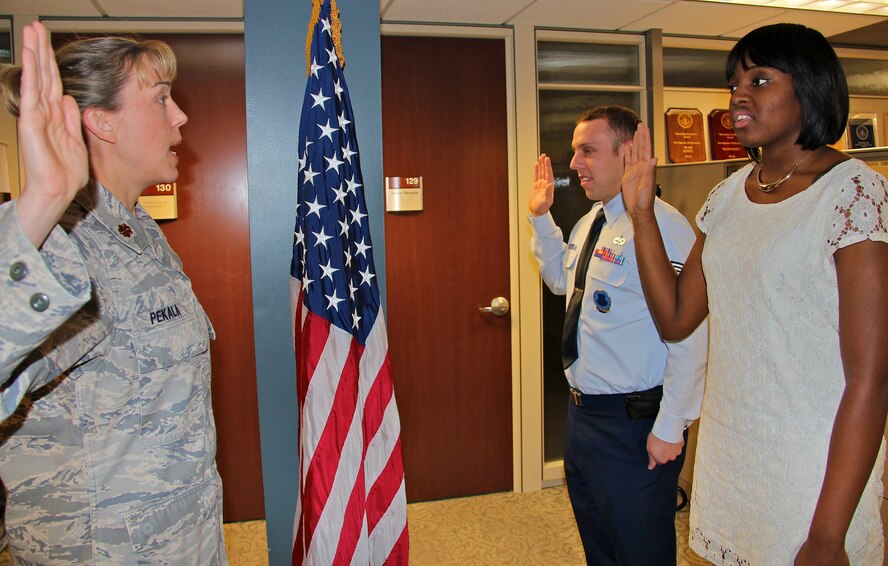 Maj. Amy Pekala administers the oath of enlistment to Tech. Sgt.  Jamie Baker-Flores, a 932nd Airlift Wing recruiter, and Steffonya Raines, his newest recruit.  Baker-Flores reenlisted for four years and Raines enlisted for six. The dual enlistment ceremony took place Dec. 27. 2012.  Raines will be assigned to the 932nd Medical Squadron after she completes basic training and techical school training. (U.S. Air Force photo/Tech. Sgt. Dan Oliver)