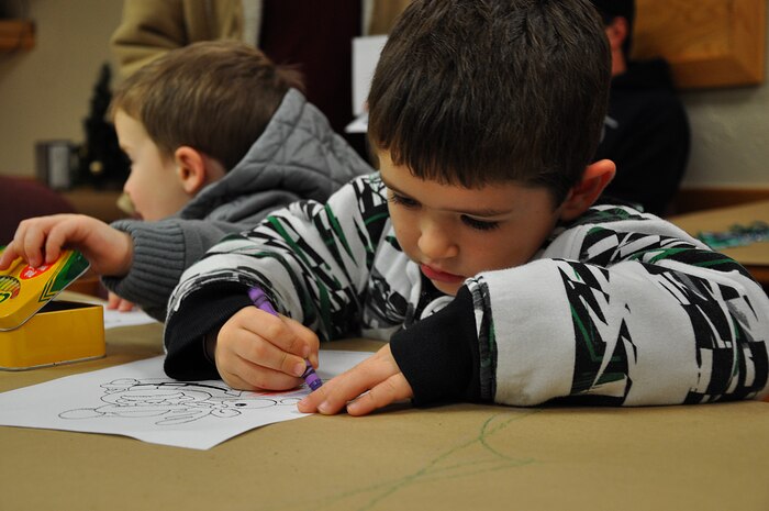 A child colors a picture of Santa Claus with Rudolph the Red-nosed Reindeer while  waiting to track Santa in his sleigh in the radar tower at the 7th Space Warning Squadron. Children and families look forward to the annual Christmas Eve event all year. (U.S. Air Force photo by 2nd Lt. Siobhan G. Bennett/Released)