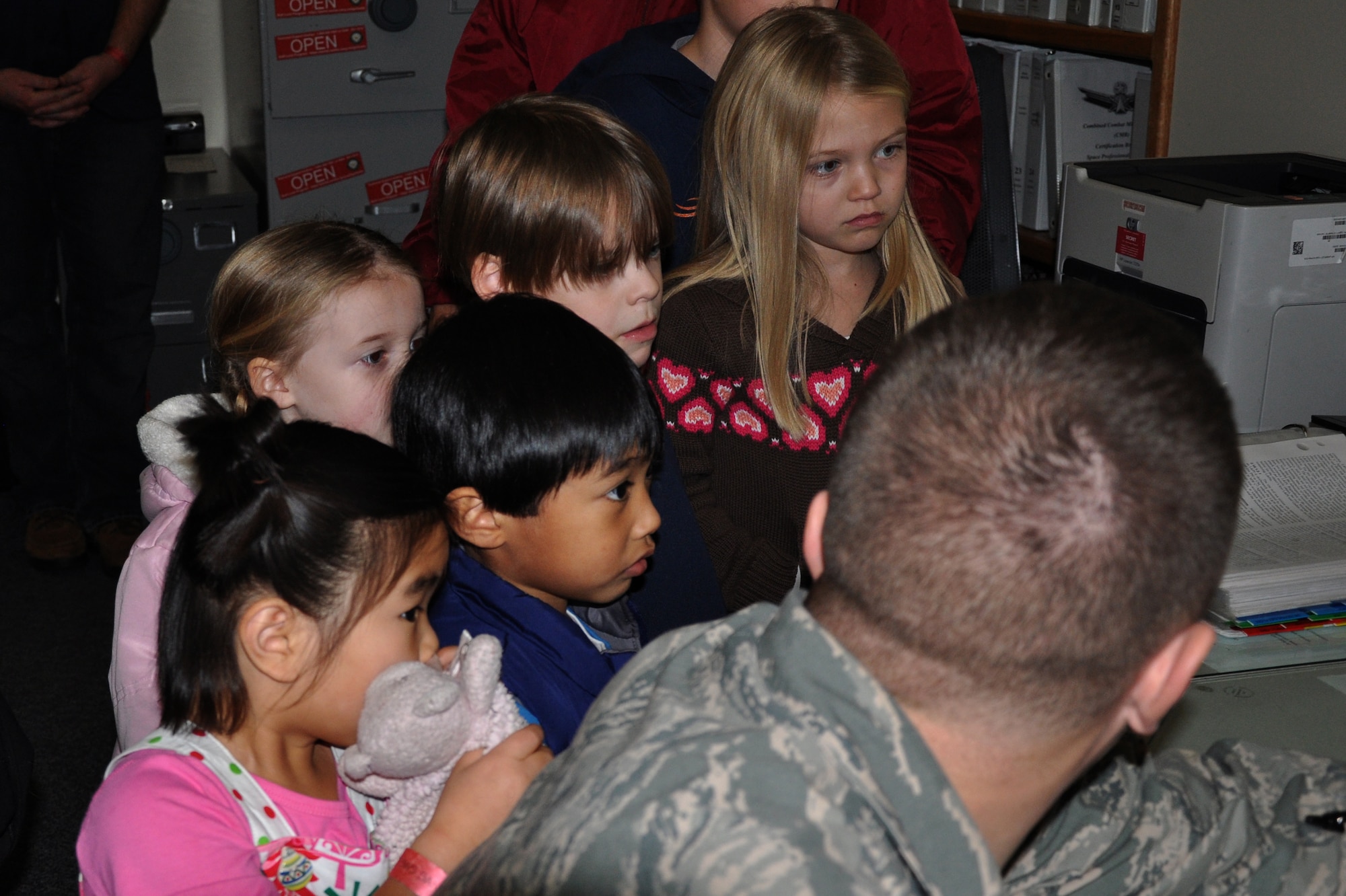 A member of the 7th Space Warning Squadron shows children where Santa is flying around the world during the NORAD Santa Tracking event on Christmas Eve. 7th SWS invites children and families primarily of deployed Airmen up to the radar tower to help track Santa Claus on his sleigh. (U.S. Air Force photo by 2nd Lt. Siobhan G. Bennett/Released)