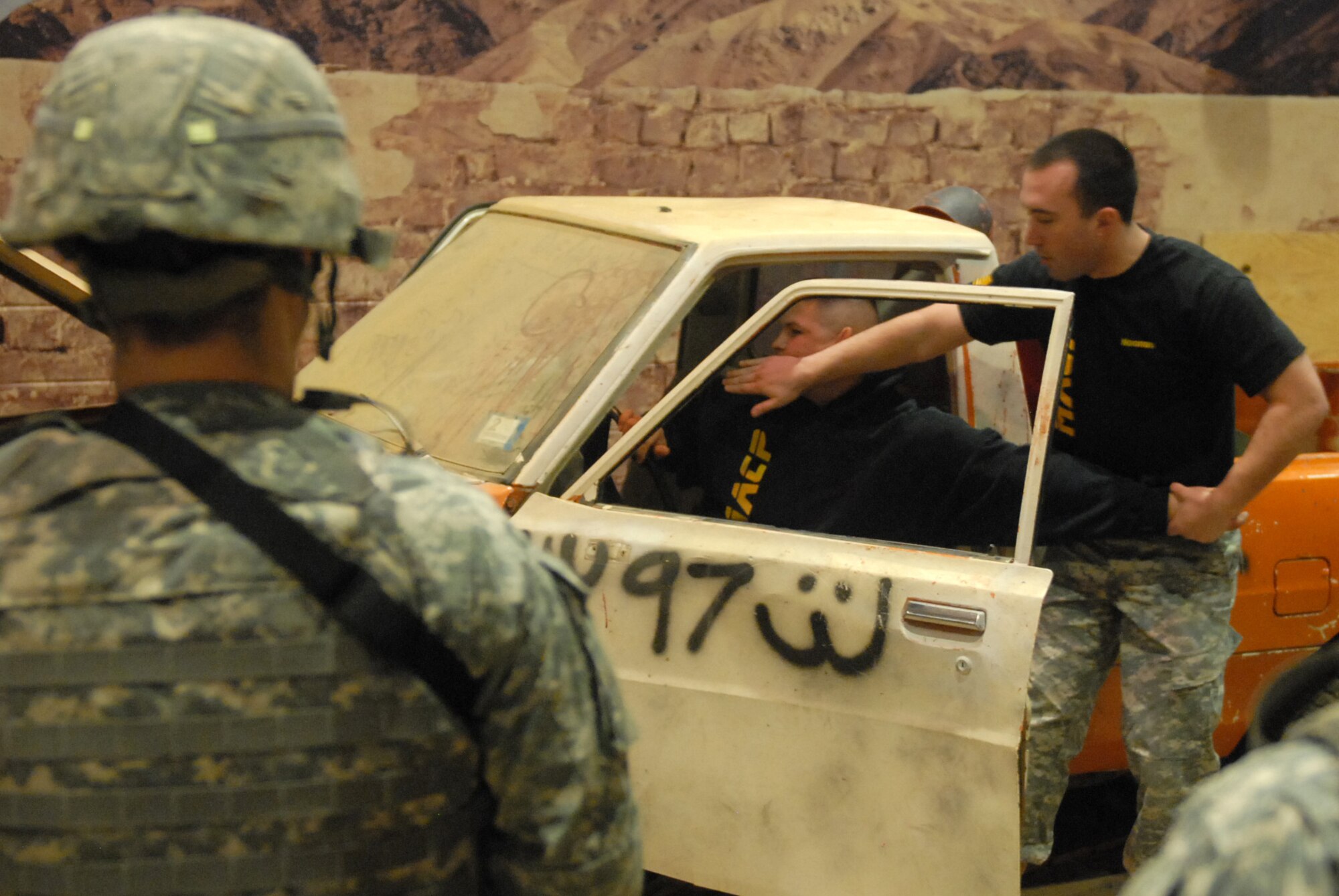 Sgt. Miles Noonan (right), with the 174th Infantry Brigade, demonstrates how to properly extract a person from a vehicle during Modern Army Combatives training at Joint Base McGuire-Dix-Lakehurst, N.J., Dec. 19, 2012. Students formed teams and demonstrated the techniques they learned in training to successfully clear buildings in a neighborhood and extract a “high value target” from a vehicle. (U.S. Army photo by Sgt. Jessi McCormick/Released)