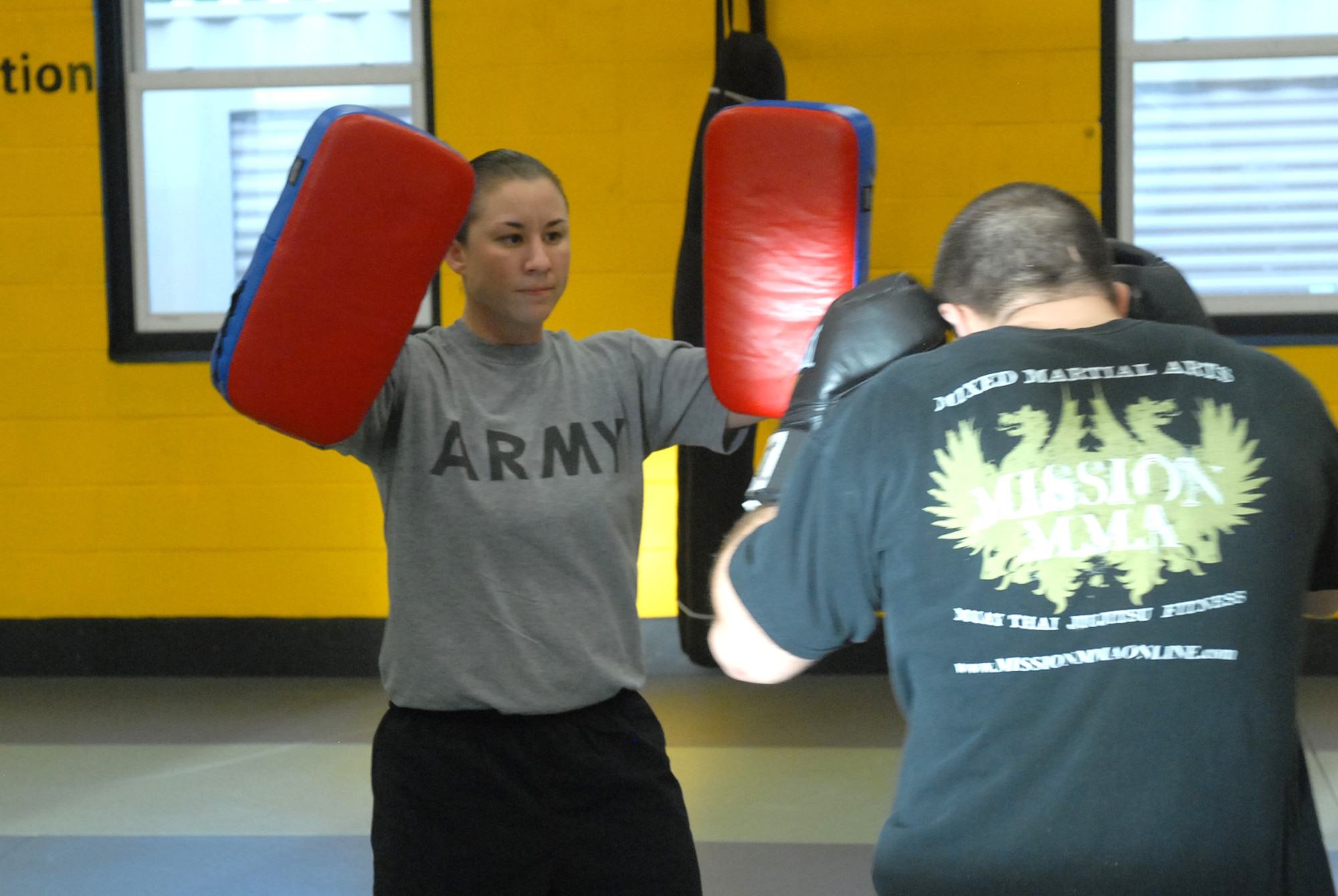 Sgt. 1st Class Cynthia Price (left) holds training bags for Robert Dell’Aquilla as he practices boxing techniques he learned during Modern Army Combatives training at Joint Base McGuire-Dix-Lakehurst, N.J., Dec. 20, 2012. The program is designed to train military personnel for real-life fighting situations, but civilians have participated from the training as well. (U.S. Army photo by Sgt. Jessi McCormick/Released)