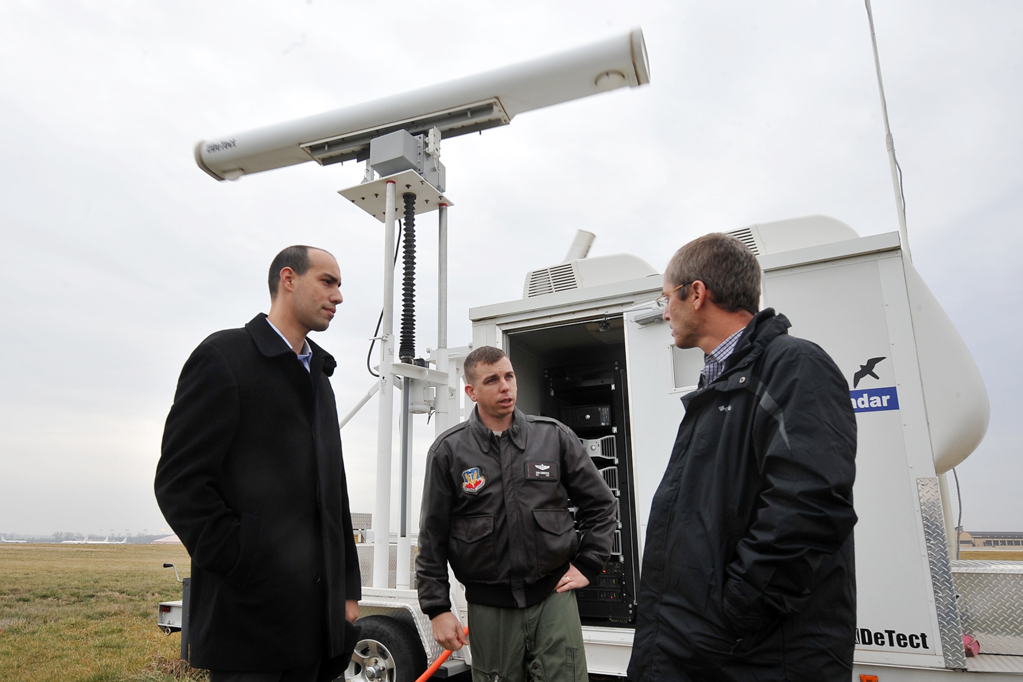 Israeli Air Force Majors Zeev Sorek and Oded Ovadia speak with U.S. Air Force Maj. Daniel Converse, 55th Wing chief of flight safety, during a briefing outside of the MERLIN Aircraft Birdstrike Avoidance Radar System Dec. 19 at Offutt AFB, Neb. The Israeli Air Force officers visited various areas during their visit, including the radar site, to learn more about the base’s BASH program. (U.S. Air Force Photo by Charles Haymond/Released)