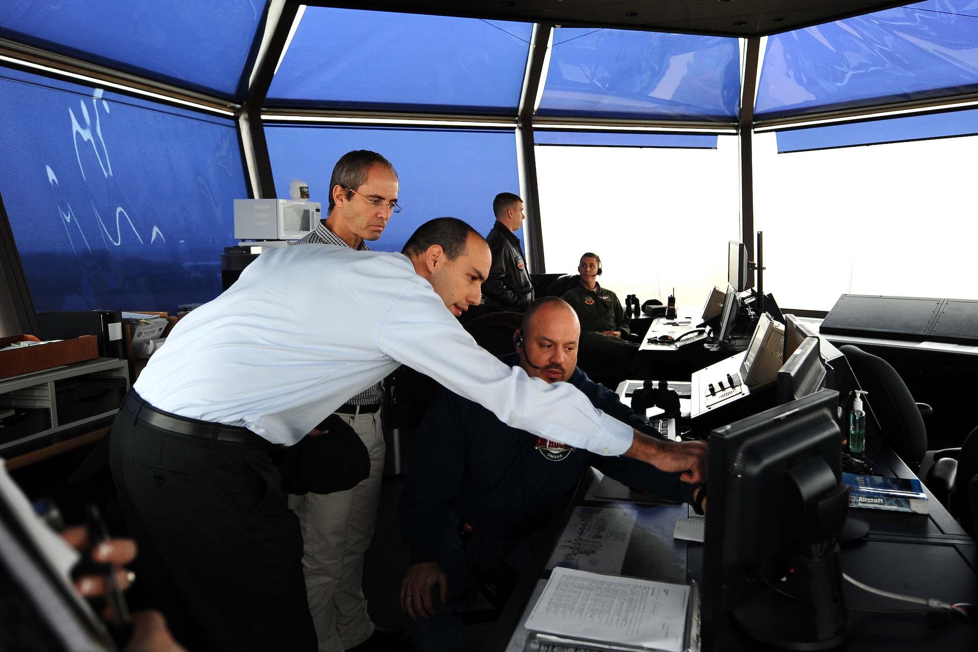 Israeli Air Force Majors Zeev Sorek and Oded Ovadia, who are both with IAF's Bird Aircraft Strike Hazard program, look at how the MERLIN Aircraft Birdstrike Avoidance Radar System is used inside Offutt’s control tower Dec. 19 at Offutt Air Force Base, Neb. The radars help identify local bird populations that could potentially damage aircraft. (U.S. Air Force Photo by Josh Plueger/Released)