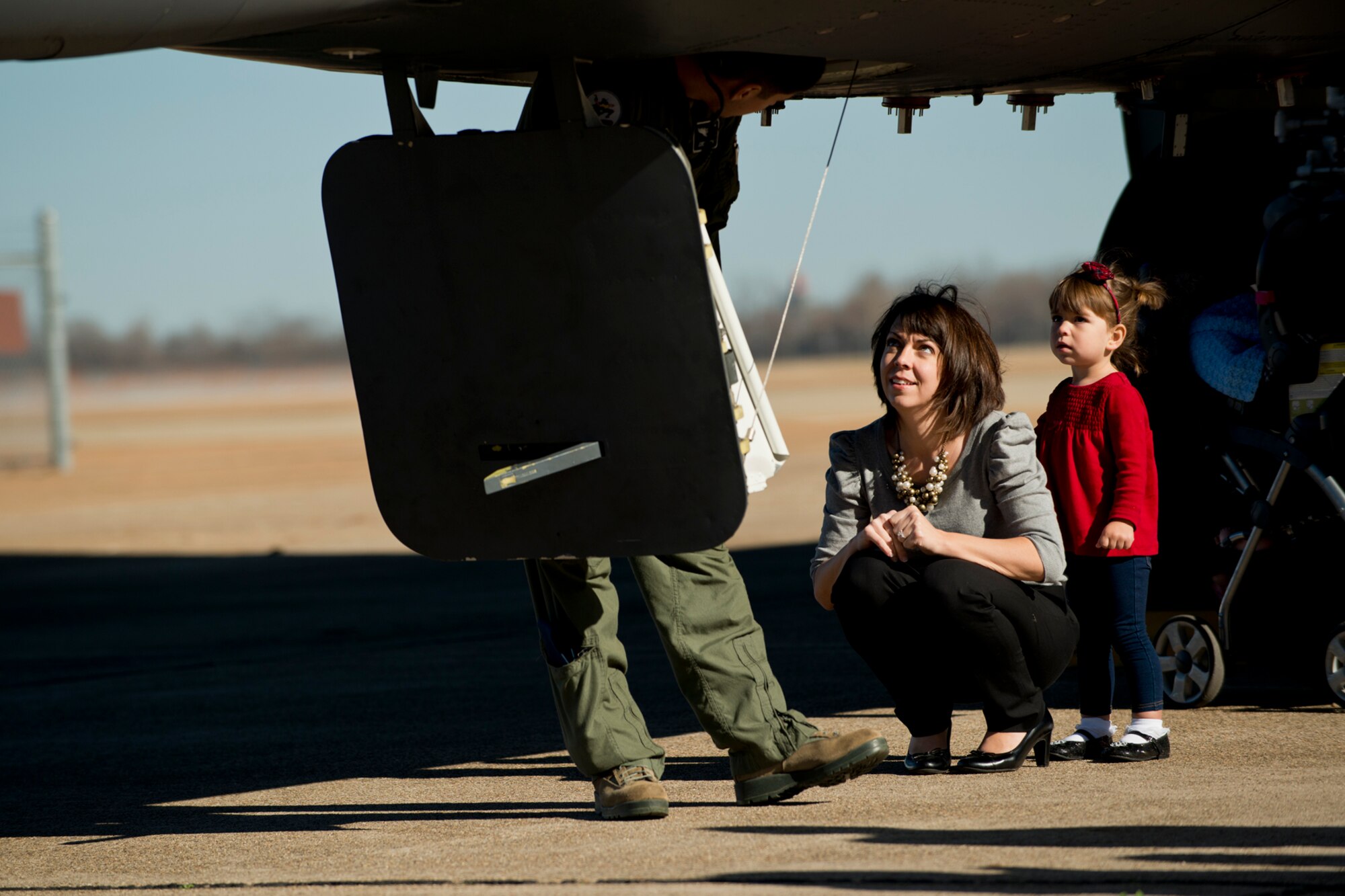 Jill Nixon and her daughter Amelia, wait their turn to climb up into the cockpit of a B-52H Stratofortress, Dec. 21, 2012, Barksdale Air Force Base, La. Jill is married to U.S. Air Force 1st Lt. Jordan Nixon, who graduated from the B-52 Formal Training Unit as a radar navigator. (U.S. Air Force photo by Master Sgt. Greg Steele/Released)