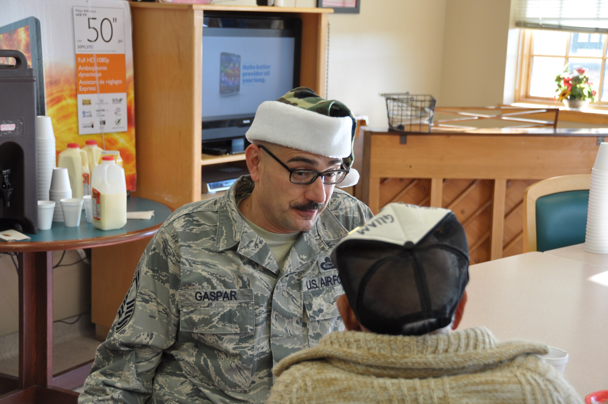 Senior Master Sgt. Robert Gaspar of the 507th Operations Support Flight, trades stories with a veteran at the Norman Veterans Center's annual Christmas party recently.  Gaspar has been attending the Christmas party for several years.  This year over $4,000 was raised by members of the 507th Air Refueling Wing for gifts to be donated to the veterans.  Members of the 507th have been donating gifts since the center opened in 1996.  (Photo by Capt. Jon Quinlan)