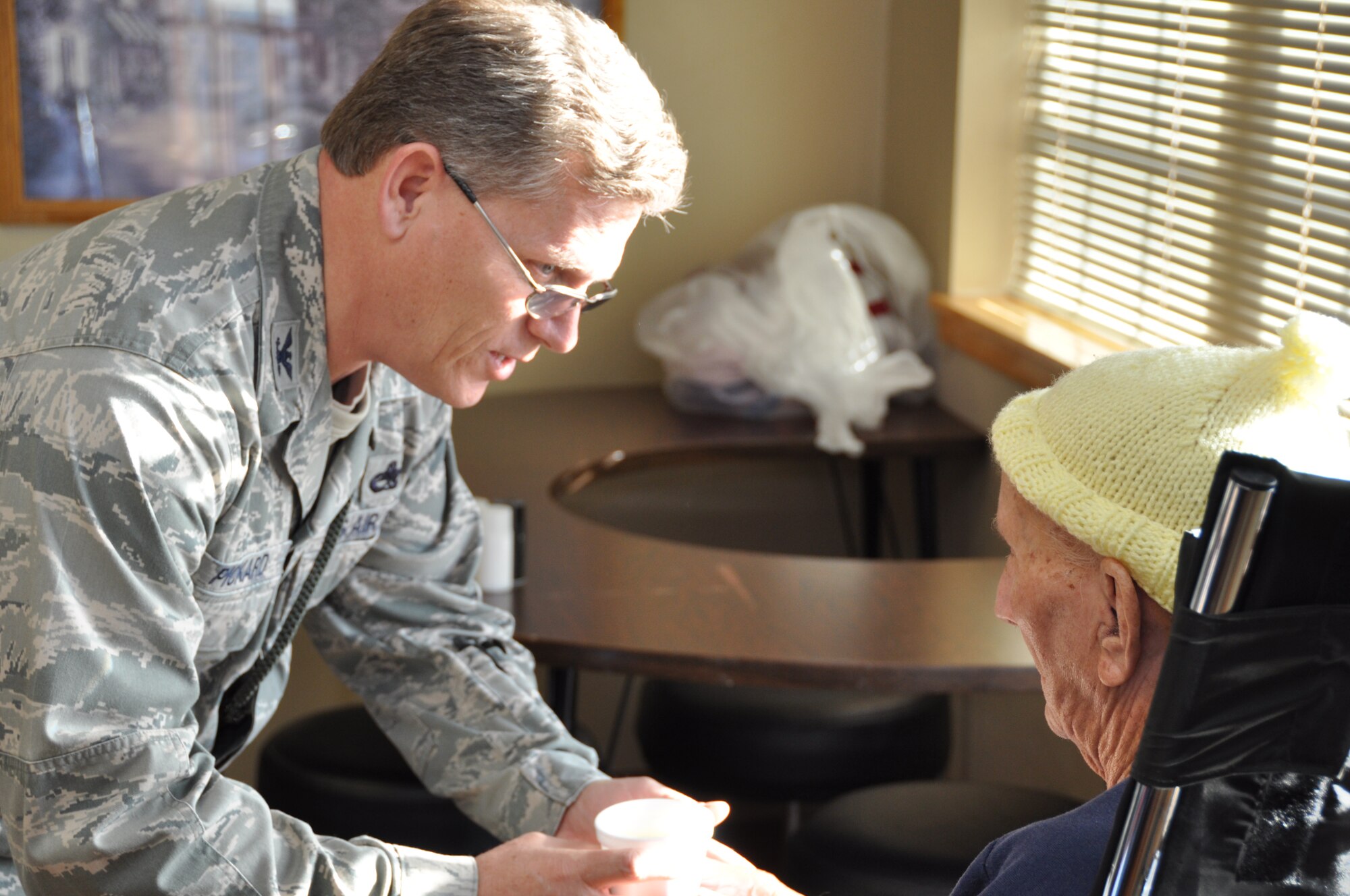 Col. Jeffrey Pickard, 507th Maintenance Group Commander offers a cup of hot chocolate to World War II veteran Albert Keim at the Norman Veterans Center recently.  Keim, who arrived in Normandy, France four days after D-Day, was one of many veterans on hand taking part in the annual Christmas Party.  Over $4,000 was raised by members of the 507th Air Refueling Wing for gifts to be donated to the veterans.  Members of the 507th have been donating gifts since the center opened in 1996.  (Photo by Senior Airman Mark Hybers)