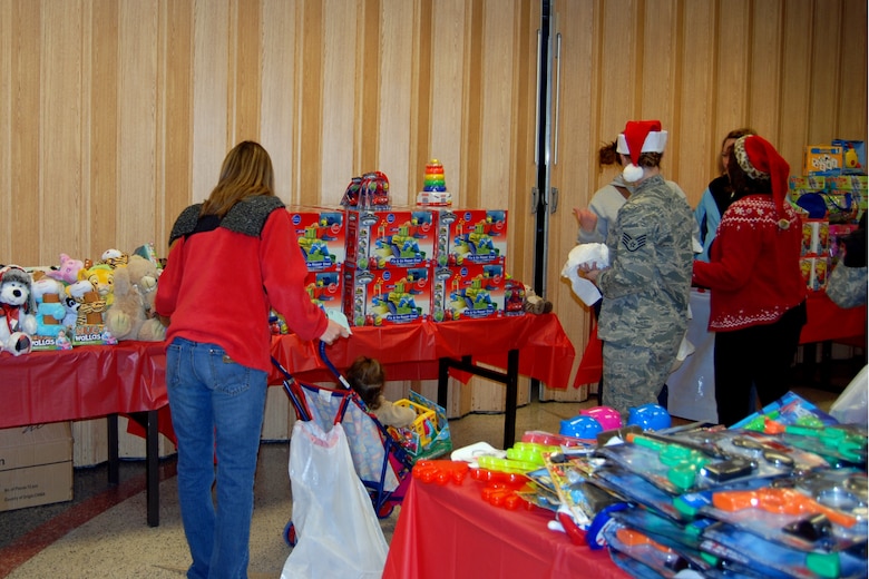 PETERSON AIR FORCE BASE, Colo. -- Volunteers help families pick out toys for their children during the Operation Homefront toy drive Dec. 10 at the chapel. Parents selected toys for 389 children during the drive. Each child received one large toy or gift card, and 20 smaller stocking stuffers. Toys were provided by Dollar Tree and other organizations as well as private donors. Volunteers from the 4th Space Company, 561st NOS, and Headquarters Air Force Space Command unloaded the toys and set up the “shopping” area. Volunteers from the key spouses and Peterson, Schriever and Cheyenne Mountain Spouses Clubs helped parents entertain children, carry bags and load cars. (U.S. Air Force photo/Lea Johnson)