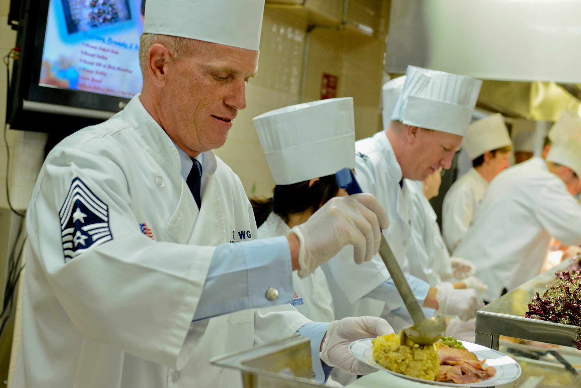 U.S. Air Force Chief Master Sgt. Frank Batten, 23d Wing command chief, pours gravy over stuffing during Christmas lunch service at the Georgia Pines Dining Facility on Moody Air Force Base, Ga., on Dec. 25, 2012. Base leadership came together to provide meals for dormitory Airmen and local area residents of Team Moody. (U.S. Air Force photo by Staff Sgt. Joshua J. Garcia/Released) 