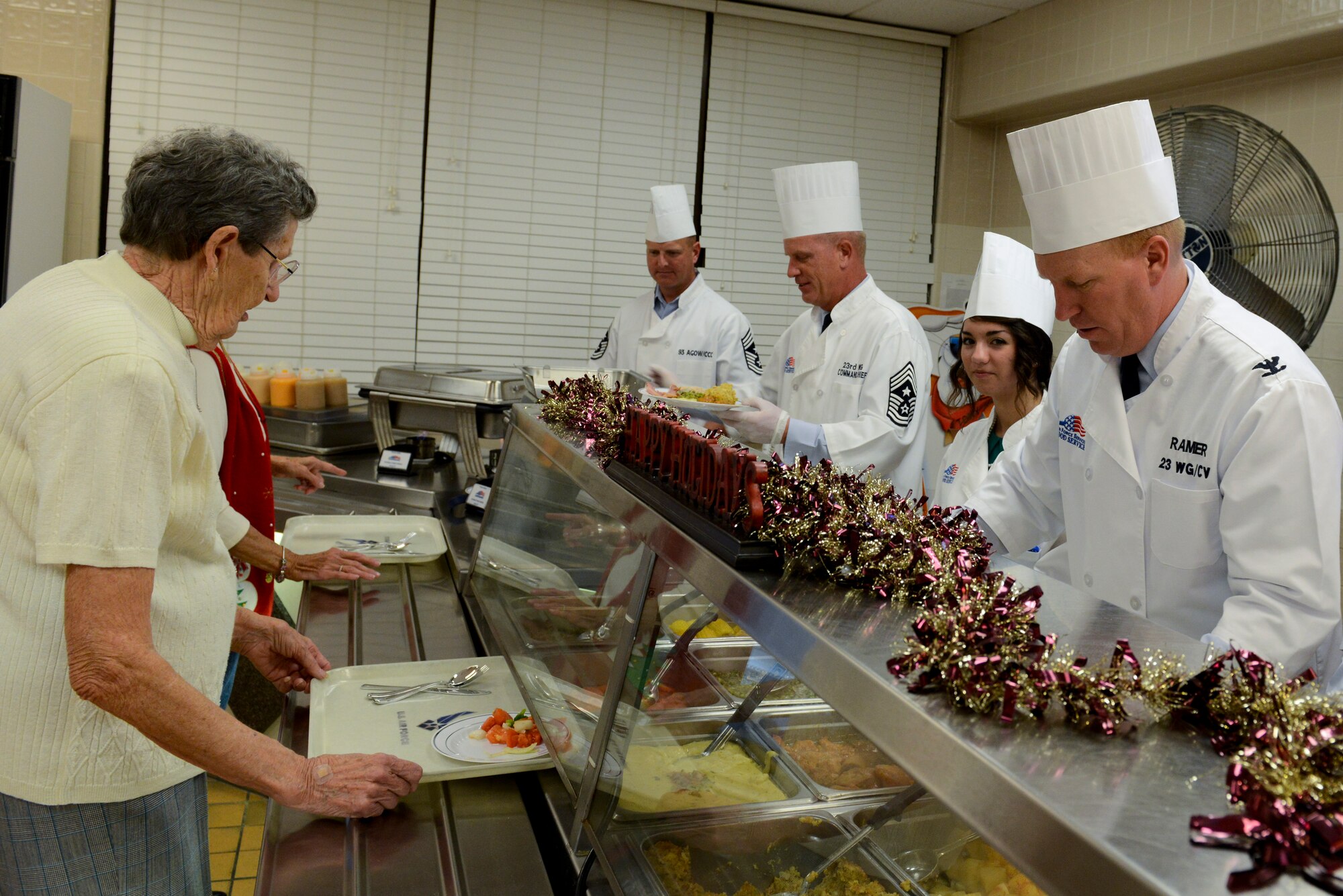 Base leadership and their families serve Christmas lunch at the Georgia Pines Dining Facility on Moody Air Force Base, Ga., Dec. 25, 2012. The lunch service consisted of turkey, ham, roast beef, and all the fixings of a traditional Christmas dinner. (U.S. Air Force photo by Staff Sgt. Joshua J. Garcia/Released)