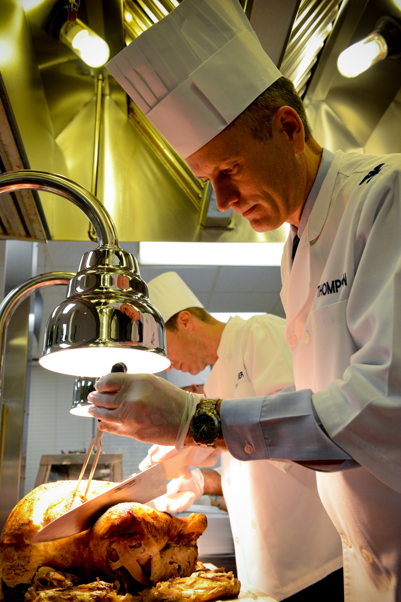 U.S. Air Force Col. Billy Thompson, 23d Wing commander, cuts turkey during Christmas lunch at the Georgia Pines Dining Facility on Moody Air Force Base, Ga., Dec. 25, 2012. Thompson and other Moody leadership served the meal to active duty members and their families as well as retirees in the local area. (U.S. Air Force photo by Staff Sgt. Joshua J. Garcia/Released) 