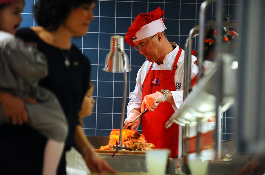 U.S. Air Force Col. Hans Palaoro, 55th Wing vice commander, works in the buffet line as he volunteers his time to serve Airman Christmas Dinner at the Ronald L. King Dining Facility on Dec. 25, Offutt Air Force Base, Neb.  Many commanders spent their day working the holiday buffet to give back to the Airmen who are unable to go home this holiday season.  (U.S. Air Force Photo by Josh Plueger/Released)