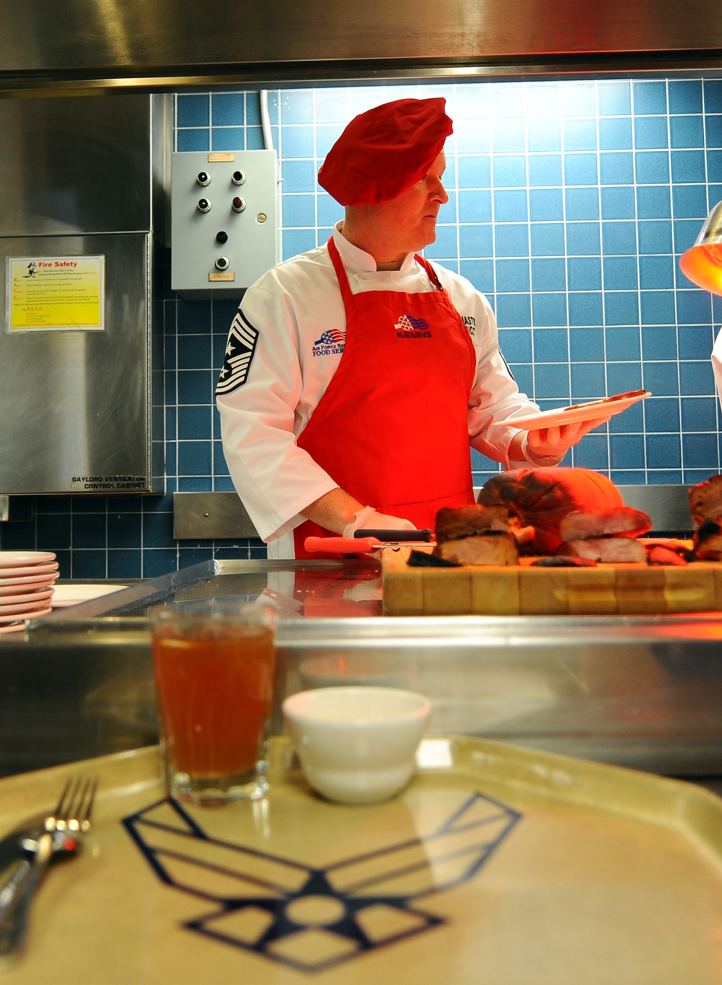 U.S. Air Force Command Chief Master Sgt. William W. Thomaston, 55th Wing command chief, dices up ham as people make their way through the Ronald L. King Dining Facility for Christmas dinner Dec. 25., Offutt Air Force Base, Neb.  Wing leadership serves meals on both Christmas and Thanksgiving as a way to say thanks to the Airmen of the 55th Wing.  (U.S. Air Force Photo by Josh Plueger/Released)