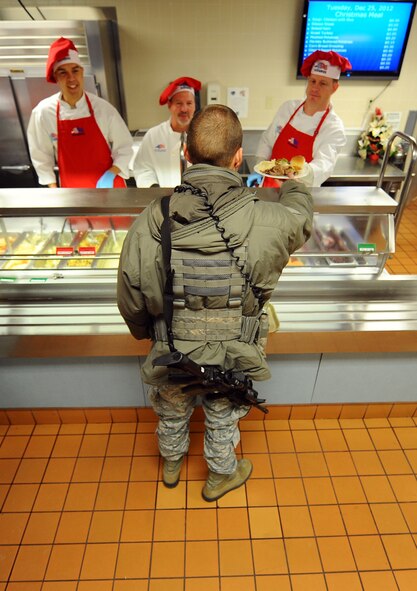 U.S. Airman 1st Class Scott Jacobs, 55th Security Forces Squadron, receives his Christmas dinner at the Ronald L. King Dining Facility Dec. 25, Offutt Air Force Base, Neb.  Many Airmen are unable to go home for the holiday season due to mission requirements.  Annually, wing leadership works at the King Dining Facility to ensure these Airmen receive a holiday meal.  (U.S. Air Force Photo by Josh Plueger/Released)