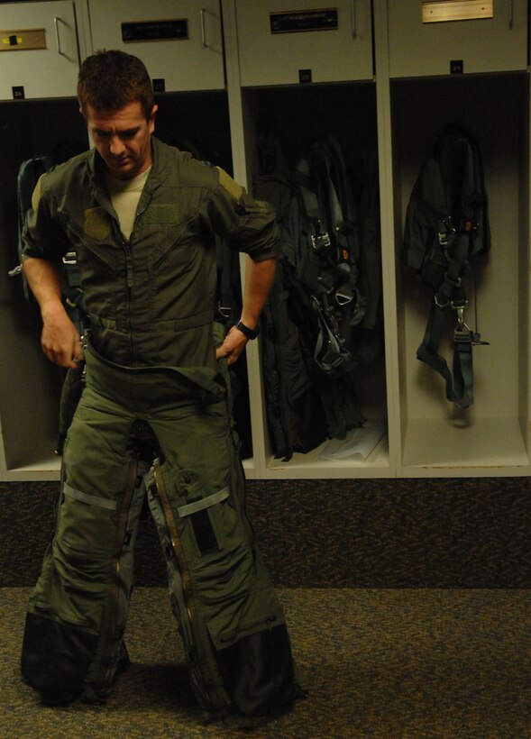 Capt. Patrick Williams, Air Force F-22 Raptor demonstration pilot, straps on his “G-suit” before flying at Langley Air Force Base, Va., Nov. 30. The suit helps the pilot maintain blood flow during flight by compressing the lower body, which decreases the amount of blood reaching the legs. (U.S. Air Force photo by Airman 1st Class Austin Harvill/Released)