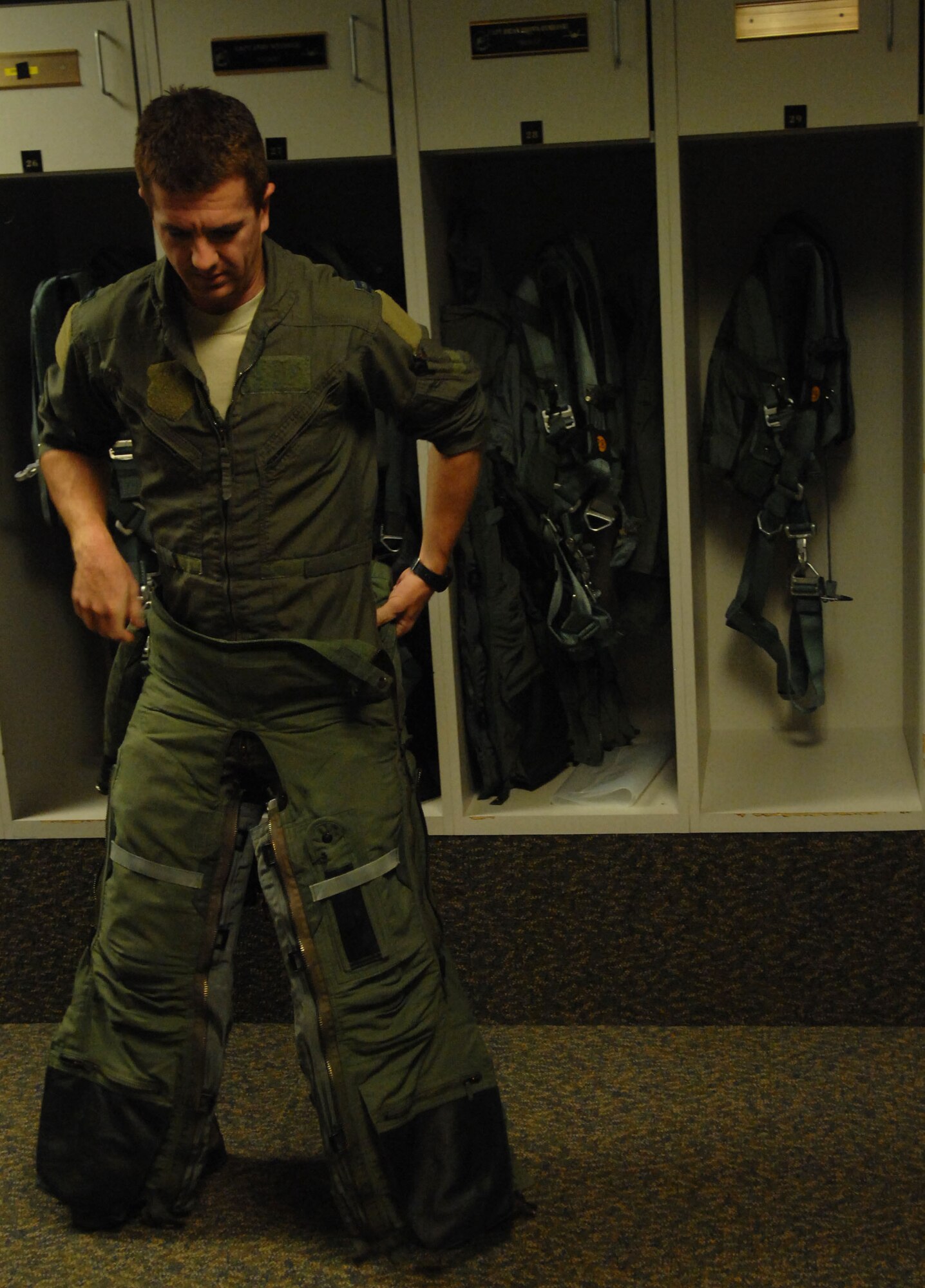 Capt. Patrick Williams, Air Force F-22 Raptor demonstration pilot, straps on his “G-suit” before flying at Langley Air Force Base, Va., Nov. 30. The suit helps the pilot maintain blood flow during flight by compressing the lower body, which decreases the amount of blood reaching the legs. (U.S. Air Force photo by Airman 1st Class Austin Harvill/Released)